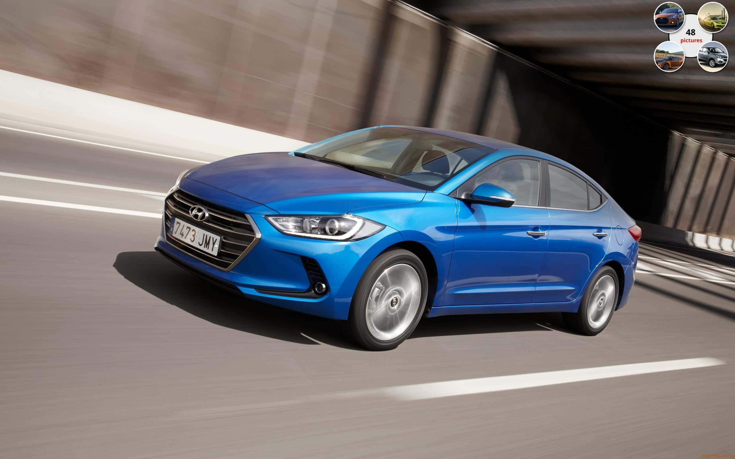 Hyundai Elantra 桌布 壁紙 — 一輛充滿活力的藍色現代伊蘭特在隧道中疾馳，動態模糊強調了其動態運動。