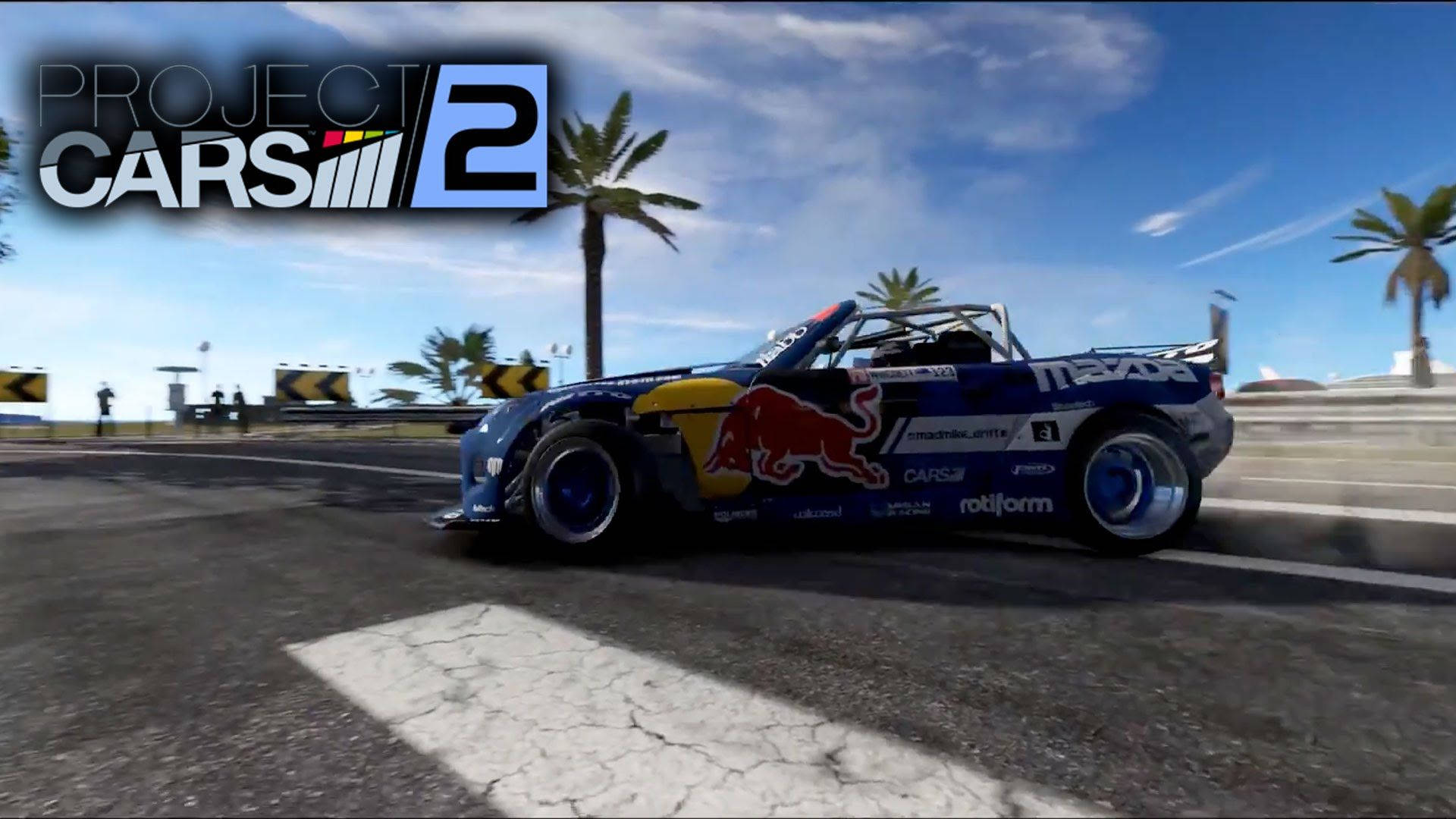 藍色Red Bull賽車在陽光明媚的海岸賽道上漂移，伴有棕櫚樹。 — Project Cars 2 壁紙
