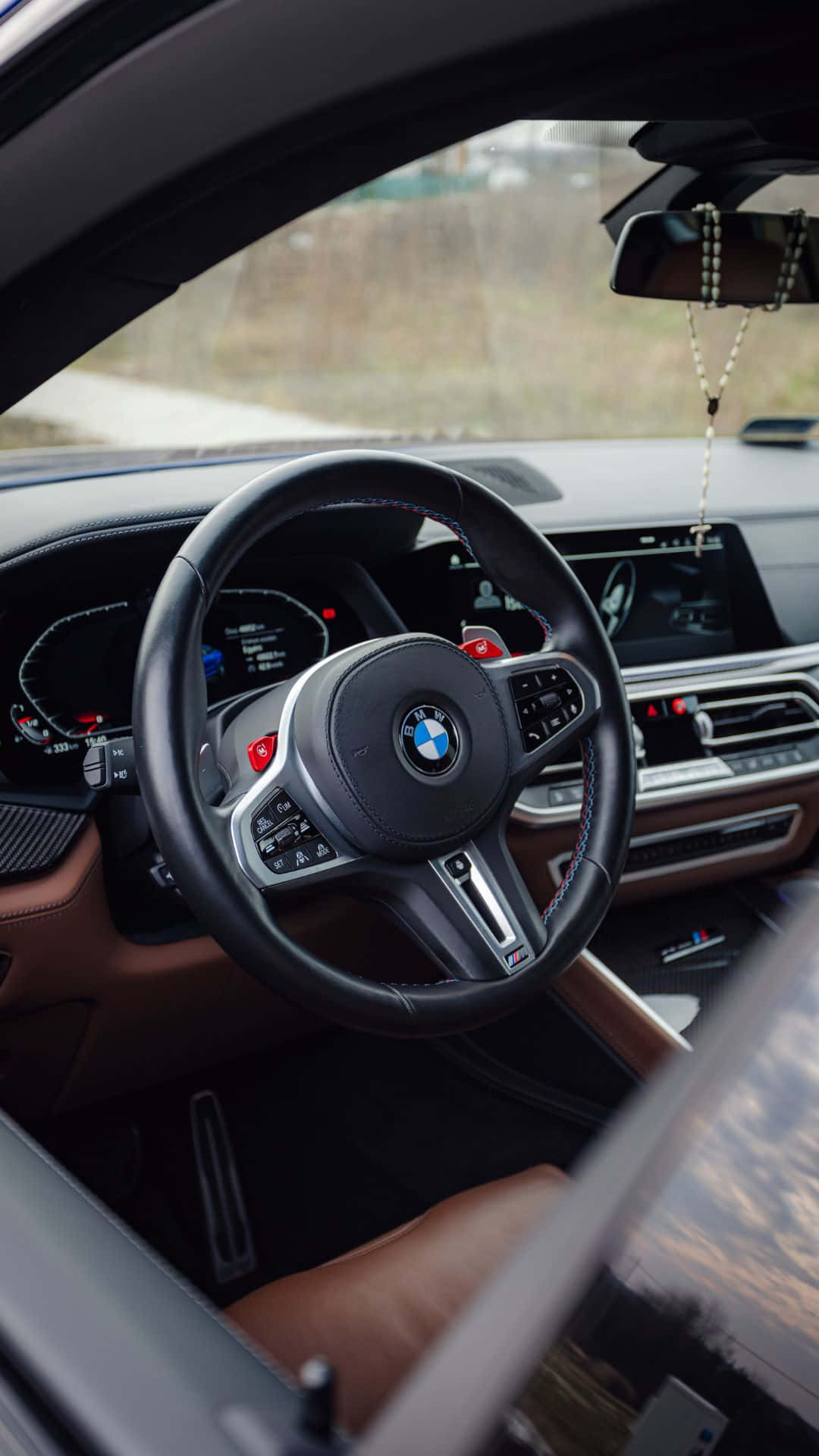 Android Bmw 桌布 壁紙 — BMW M 車豪華黑色皮革方向盤近距離特寫，帶有紅色點綴和數位儀表板。