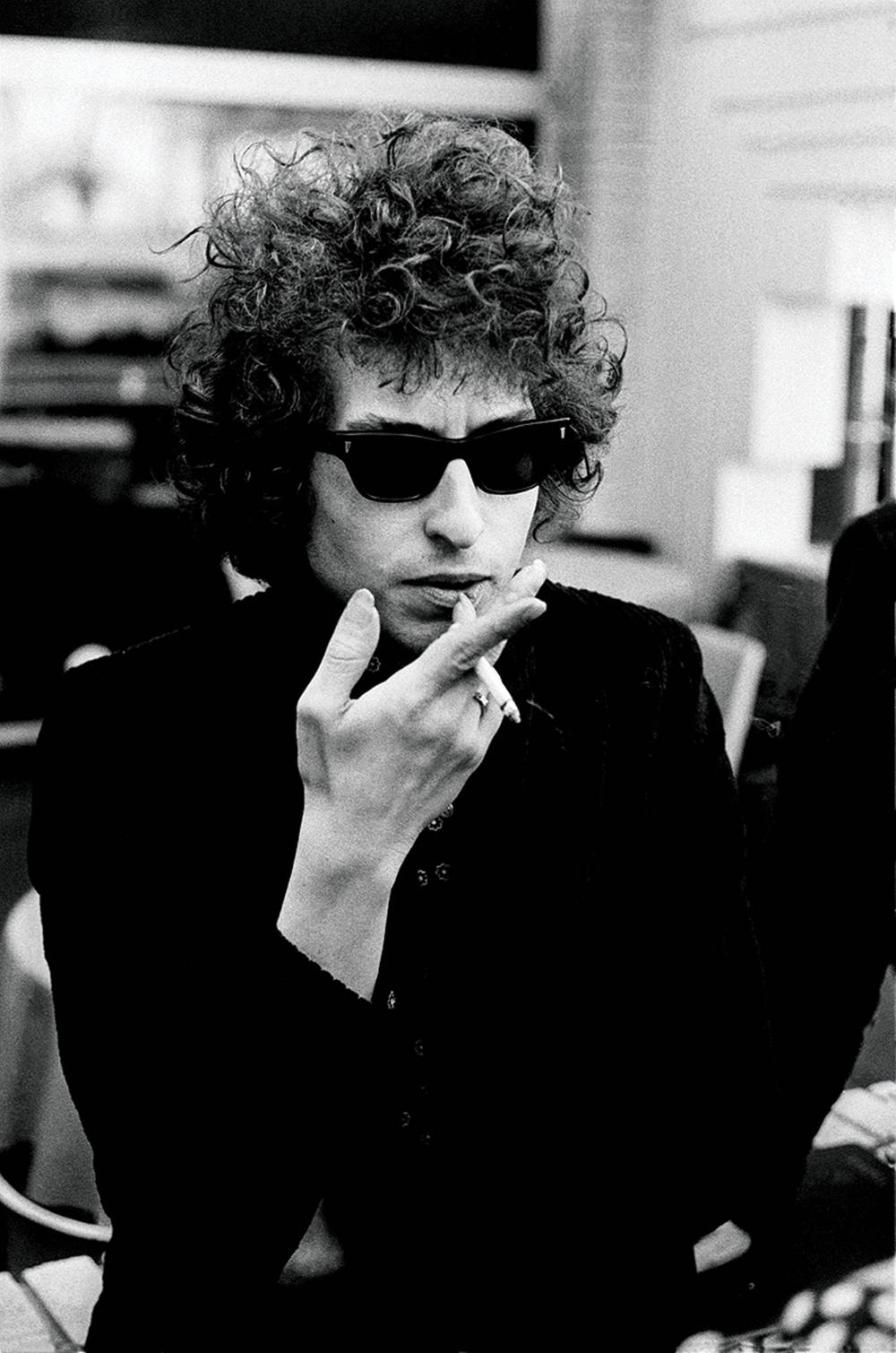 黑白 桌布 壁紙 — Bob Dylan 戴著太陽眼鏡和深色外套，在一張自然的黑白照片中抽煙。