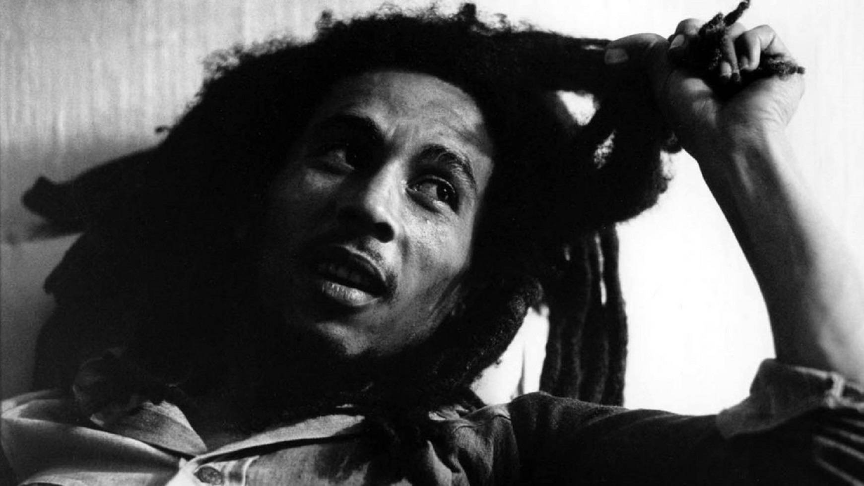 Bob Marley 桌布 壁紙 — Bob Marley 向上凝視，表情強烈，手抓著他的辮子，呈現戲劇性的黑白肖像。