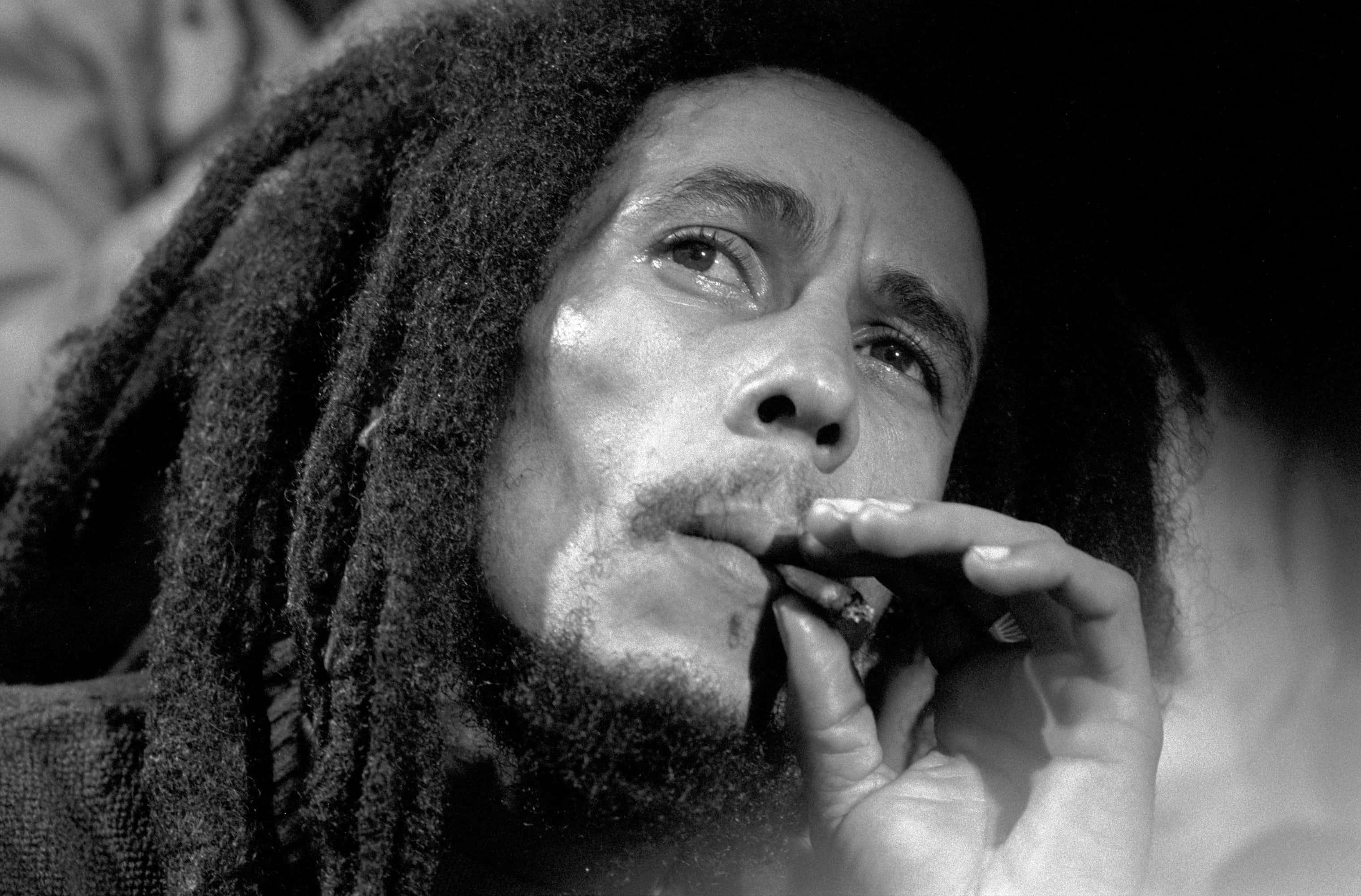 Bob Marley 桌布 壁紙 — Bob Marley 吸煙的黑白特寫，眼神向上凝視，帶有紋理的辮子。