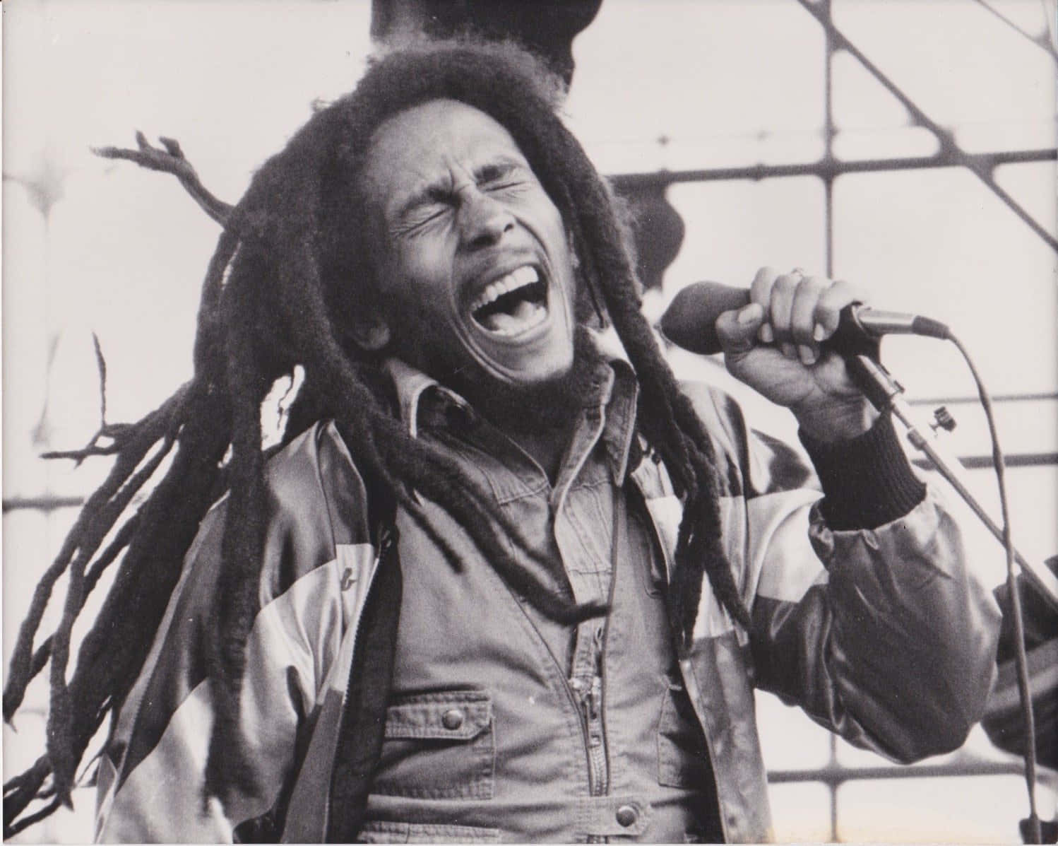 Bob Marley 桌布 壁紙 — Bob Marley 在黑白照片中閉上眼睛，張大嘴巴，熱情地唱入麥克風。