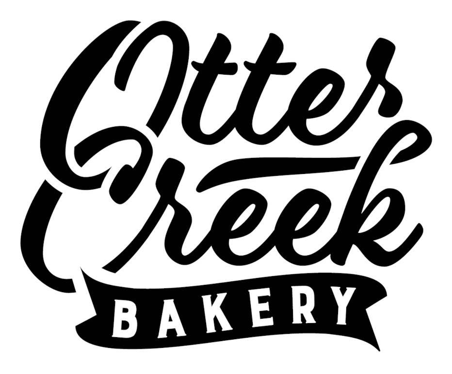 烘焙坊 桌布 壁紙 — Otter Creek Bakery 大膽的黑白標誌，帶有流暢的字體和絲帶橫幅。
