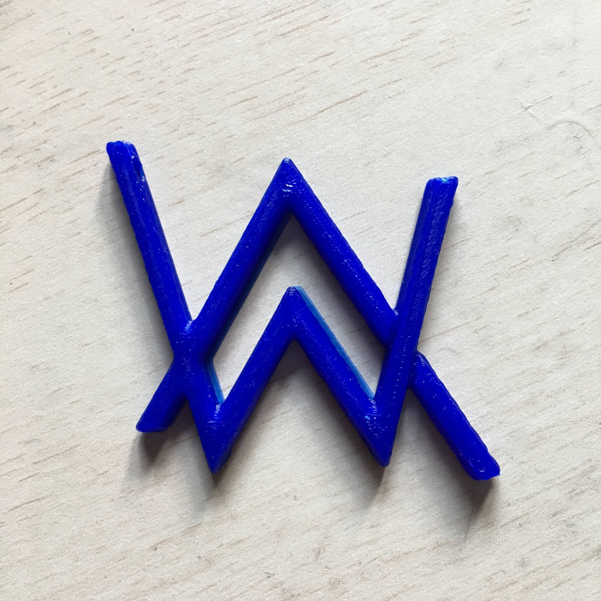 淺色木質表面上的藍色3D列印W標誌 — 3D 壁紙