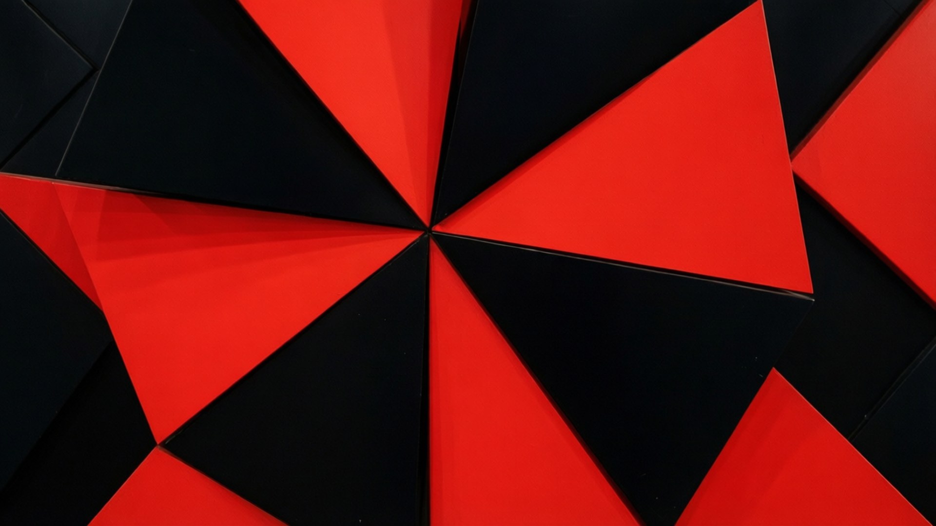 Geometric Pinwheel Abstraction 壁紙 — 一個大膽的幾何圖案，由交替的紅色和黑色三角形面板從中心點向外輻射。