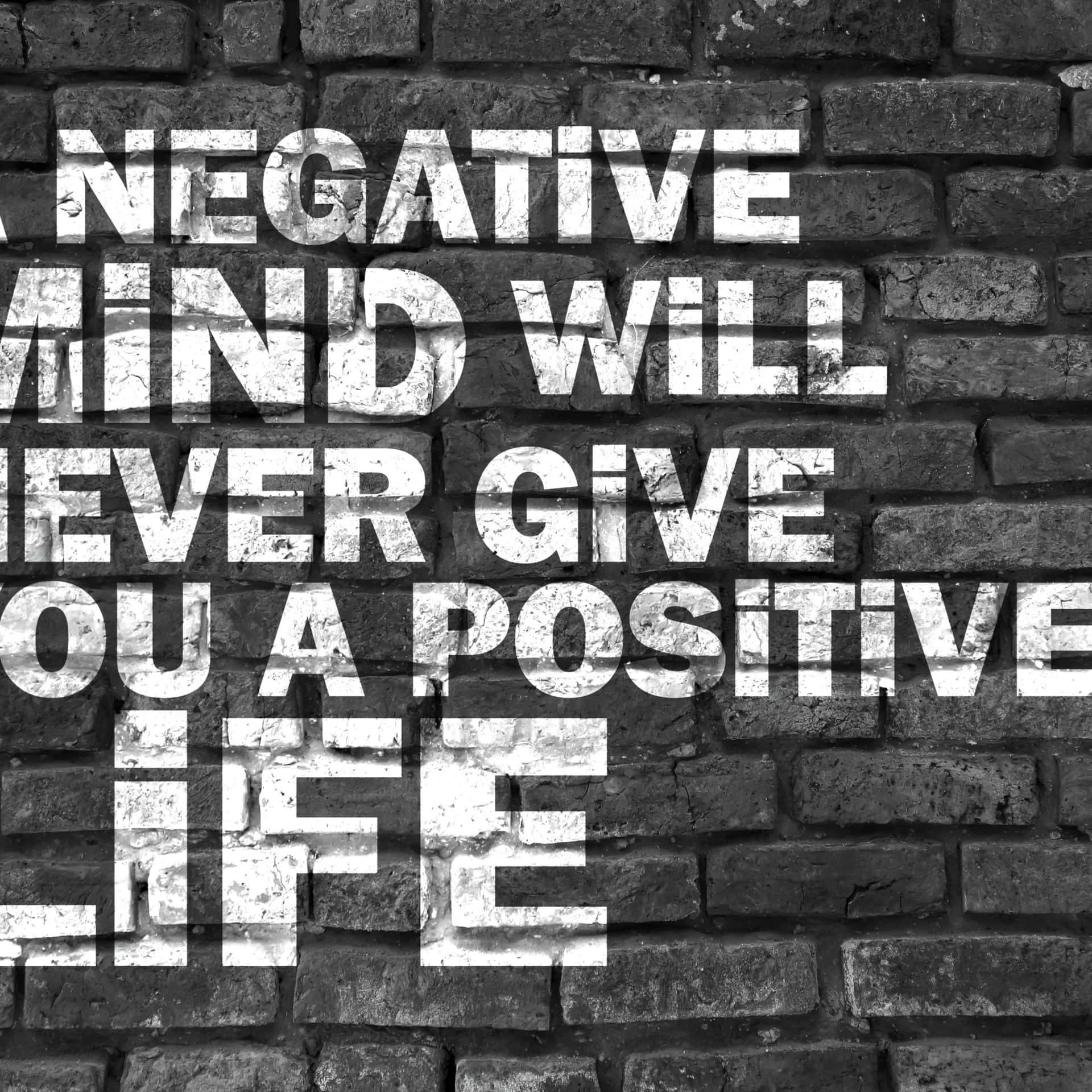  壁紙 — 單色風化磚牆上，粗體白色文字宣告「A NEGATIVE MIND WILL NEVER GIVE YOU A POSITIVE LIFE」。