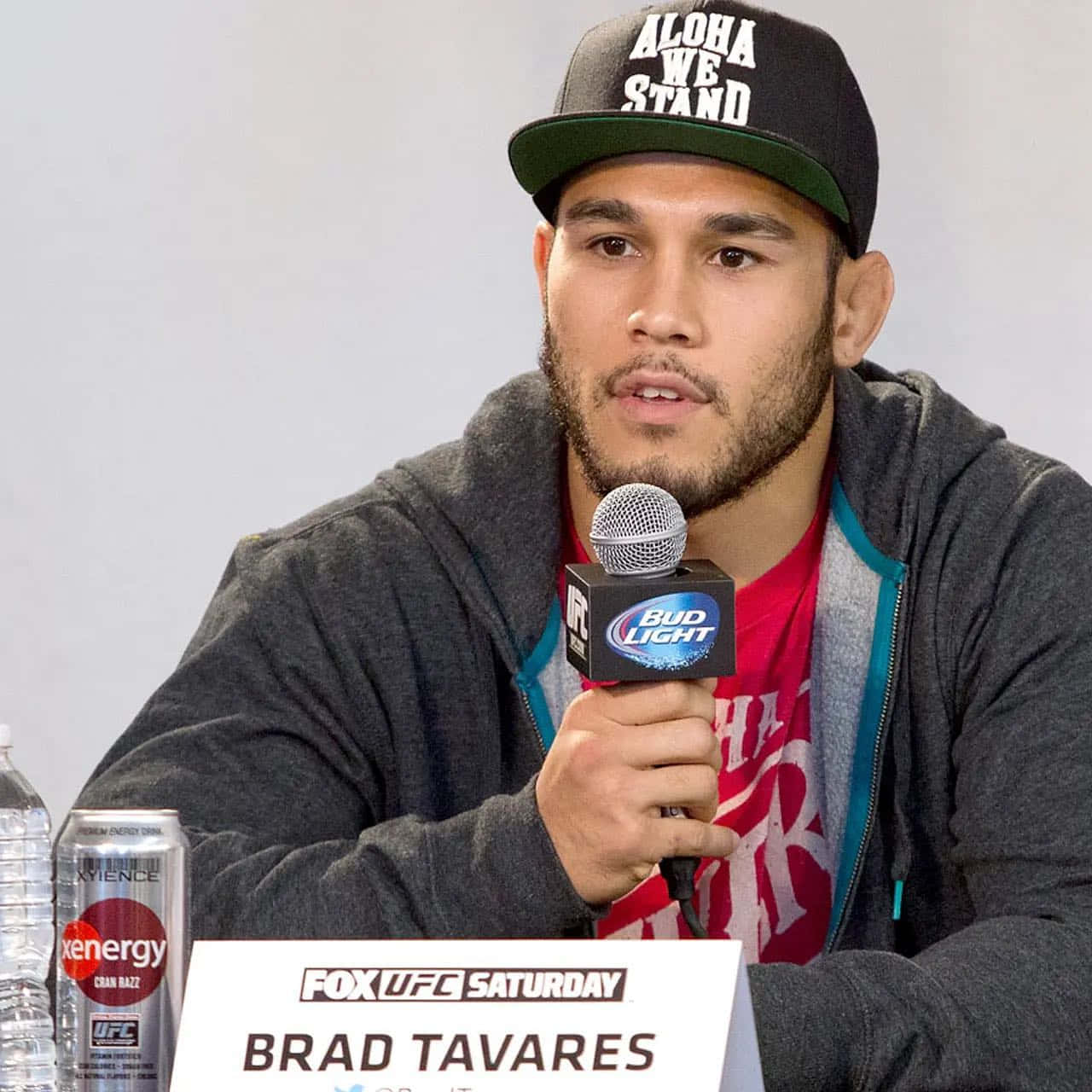 MMA 桌布 壁紙 — Brad Tavares 在UFC記者會上戴著帽子和連帽衫對著麥克風講話。