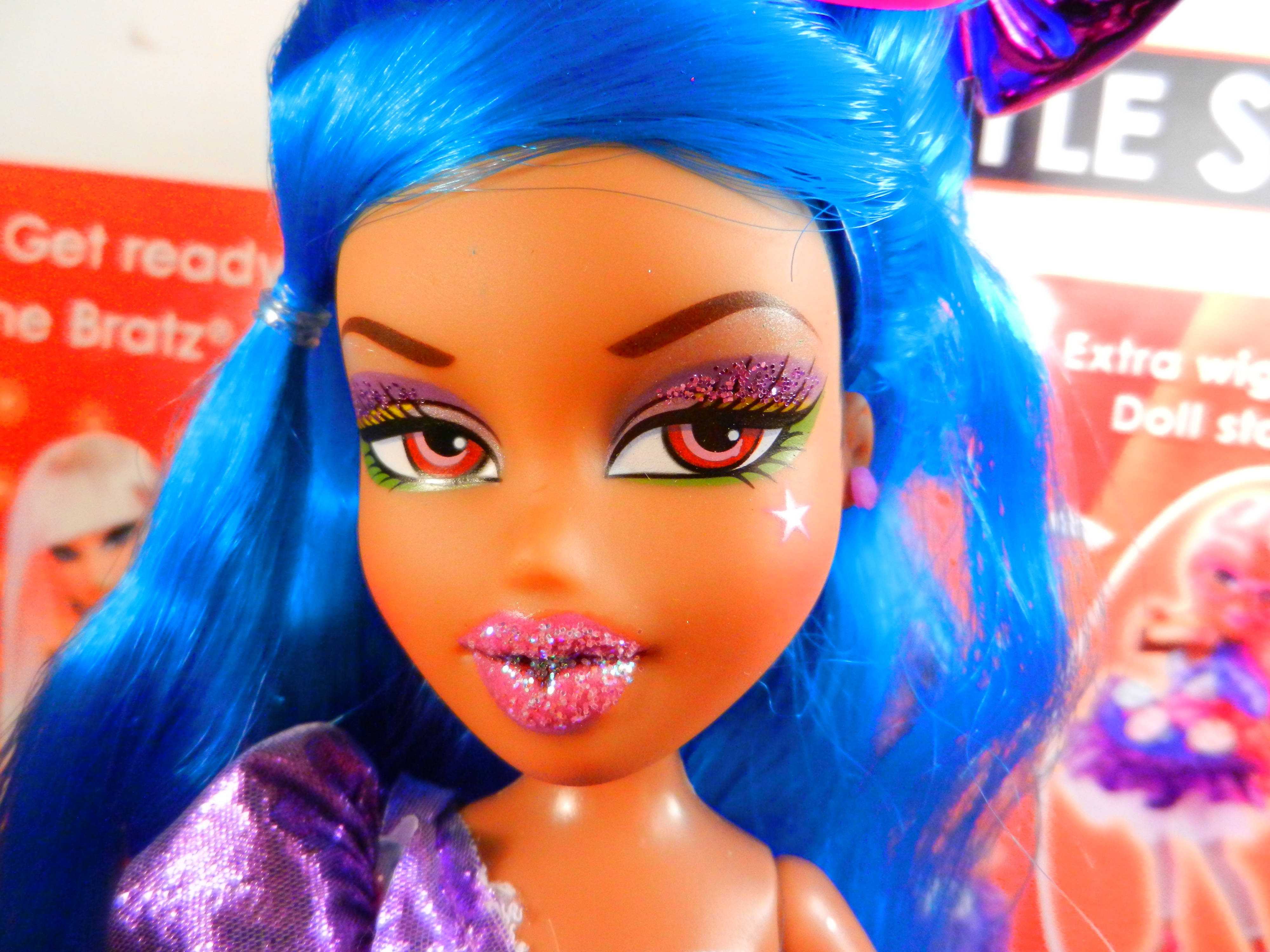 bratz 美學 桌布 壁紙 — Bratz 娃娃的特寫，擁有充滿活力的藍色頭髮、閃亮的粉紅色嘴唇和大膽的紫色閃粉眼妝。