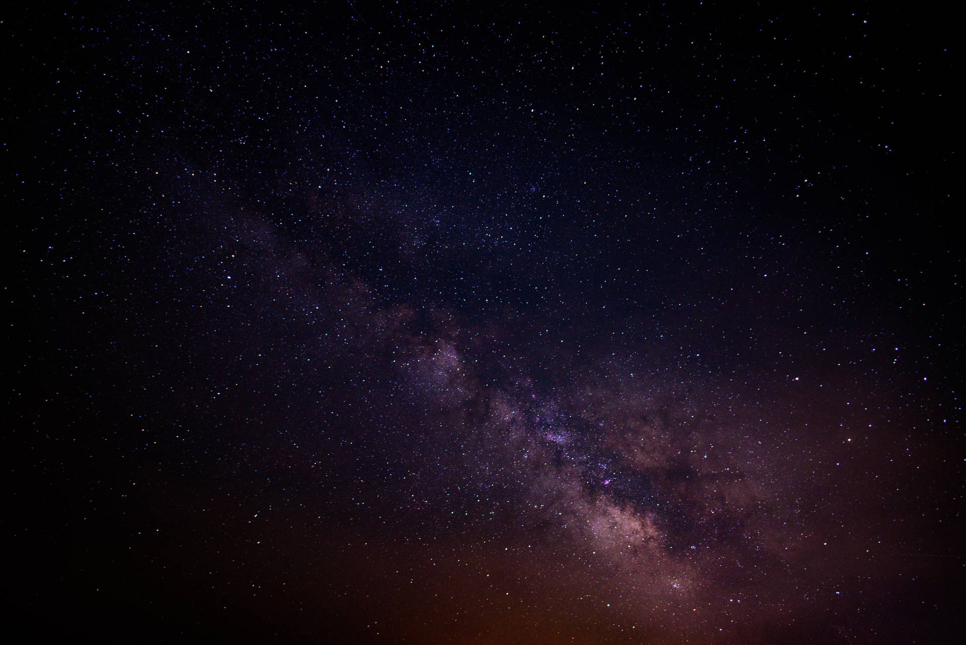 銀河系在黑暗的夜空中閃爍著紫色和粉紅色的星星。 — Galaxy S10 壁紙