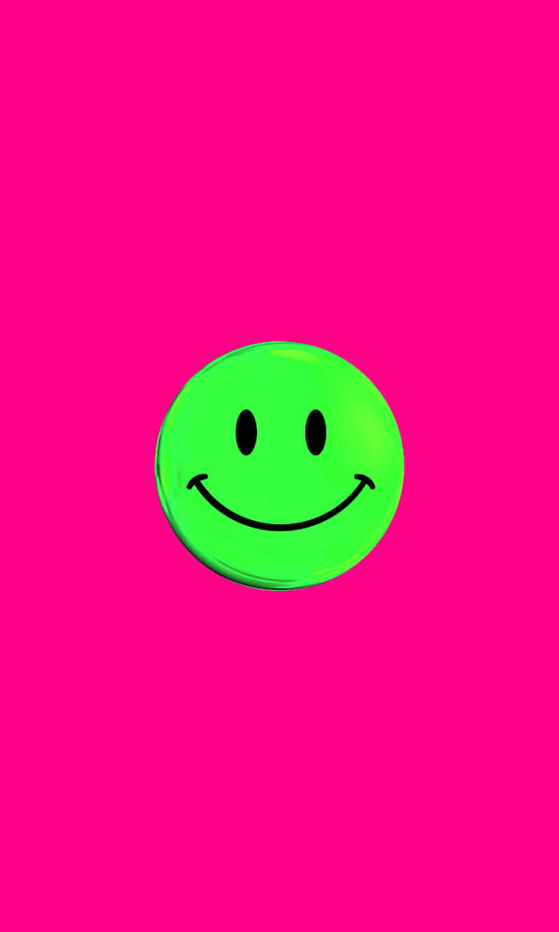 Pink Smiley Face 桌布 壁紙 — 一個明亮的綠色笑臉圖示，居中在鮮豔的粉紅色背景上，帶有柔和的光線。