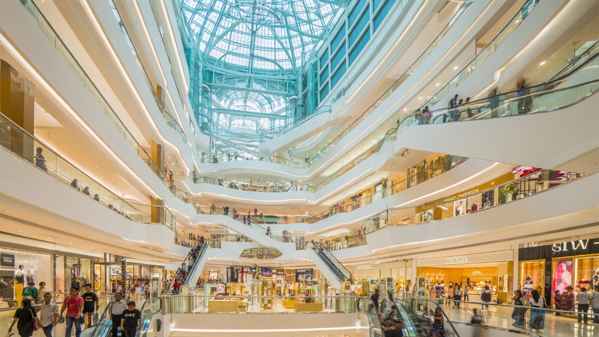 Grand Indonesia Luxury 壁紙 — 明亮的多層購物中心，設有玻璃電扶梯、弧形陽台和一個讓自然光線透入的大型玻璃穹頂天花板。