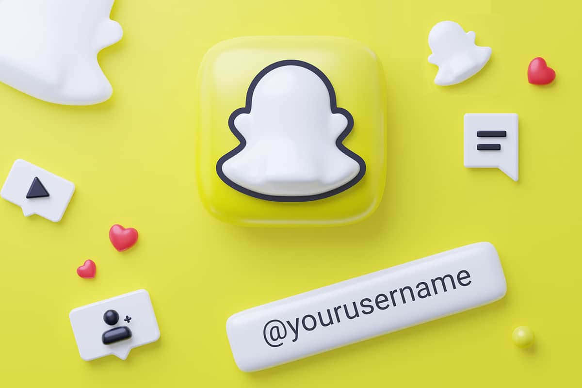  壁紙 — 一個亮黃色3D渲染的Snapchat應用程式圖示，周圍環繞著白色鬼魂表情符號和社交媒體符號，背景為鮮豔的黃色。