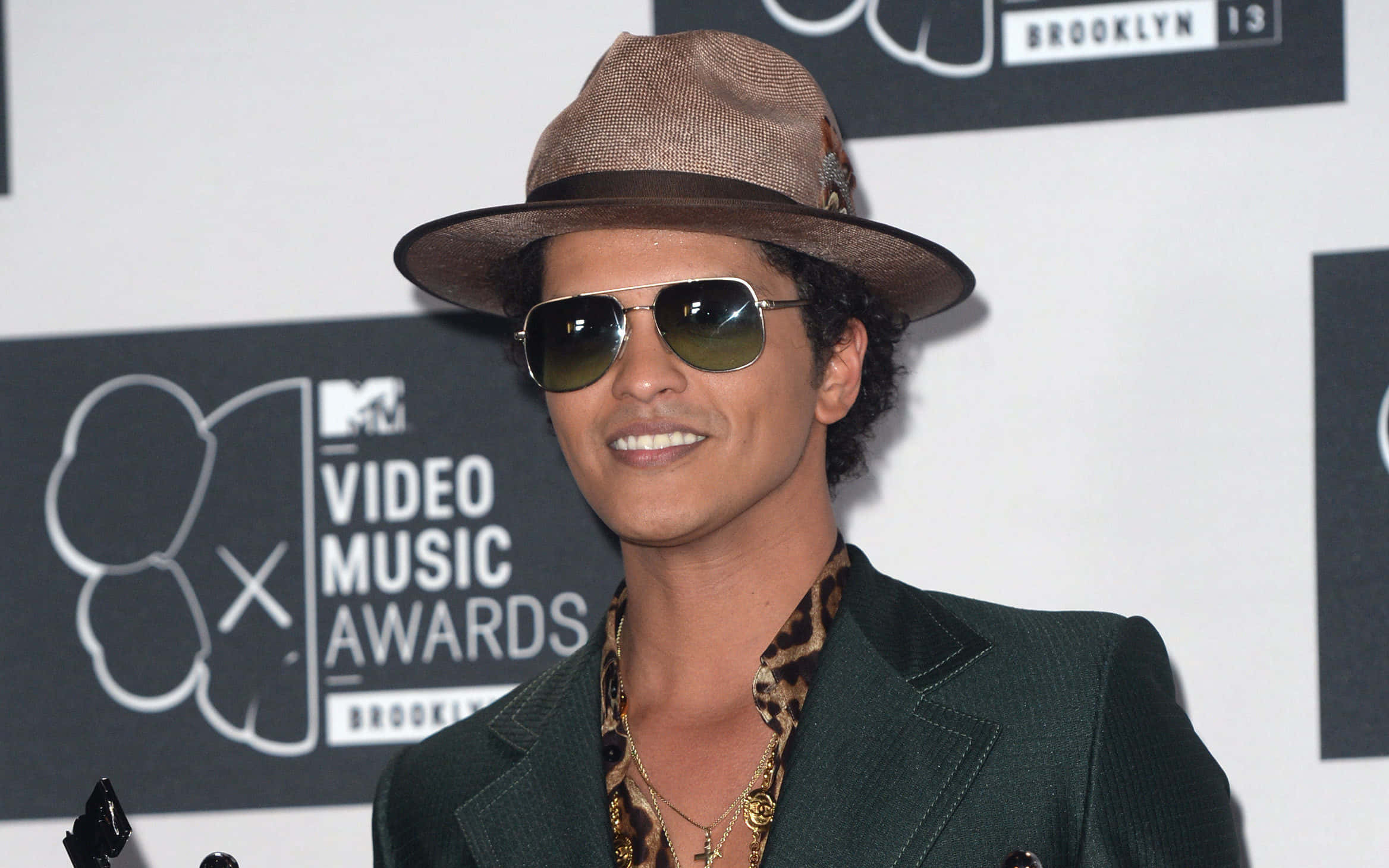 Bruno 桌布 壁紙 — Bruno Mars 在MTV音樂錄影帶大獎上戴著棕色軟呢帽和飛行員太陽眼鏡，自信地微笑。
