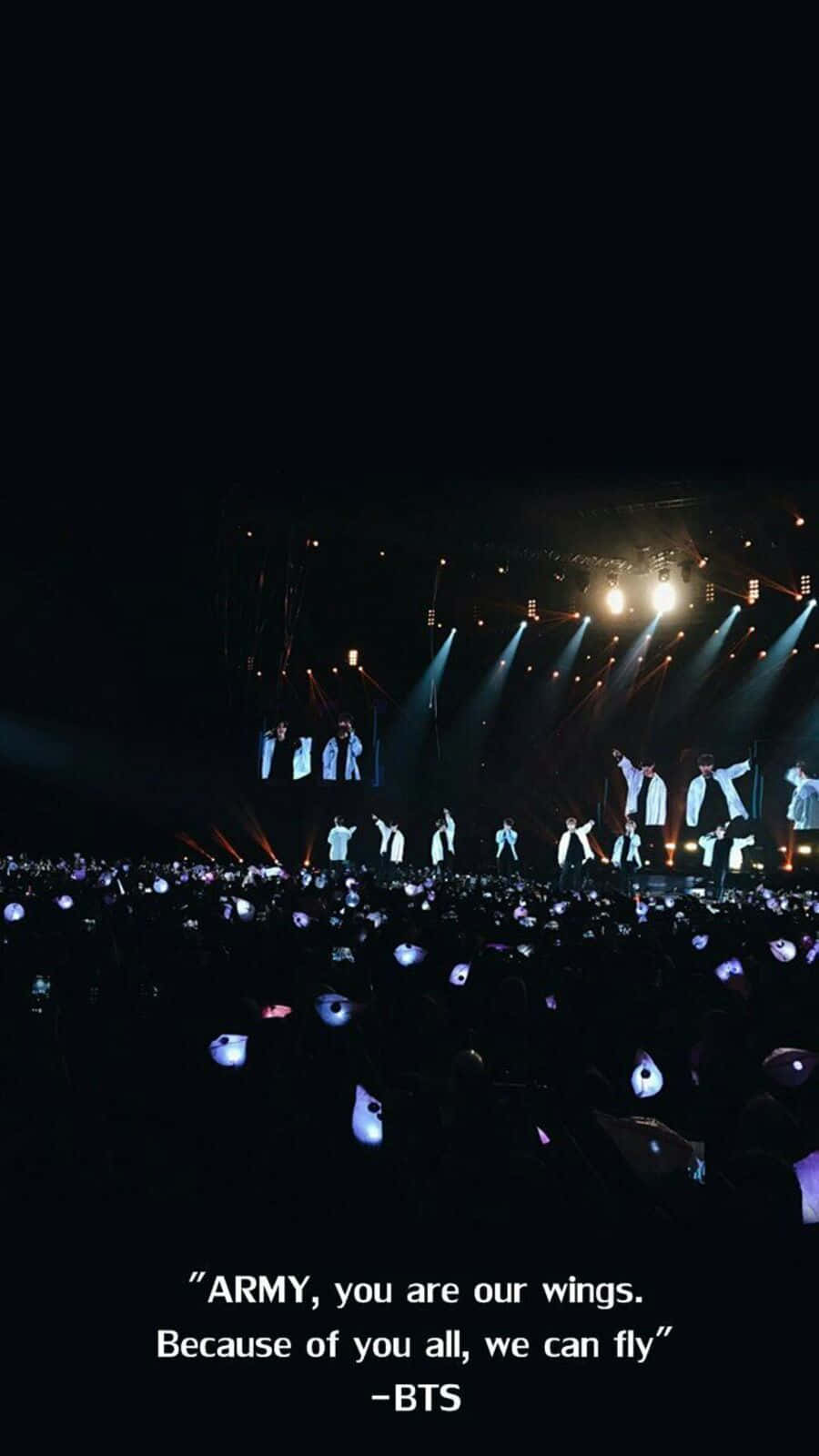 Bts Army Bomb 桌布 壁紙 — BTS在黑暗的舞台上，在明亮的聚光燈下表演，下方人群中的手機燈光如海洋般閃爍。