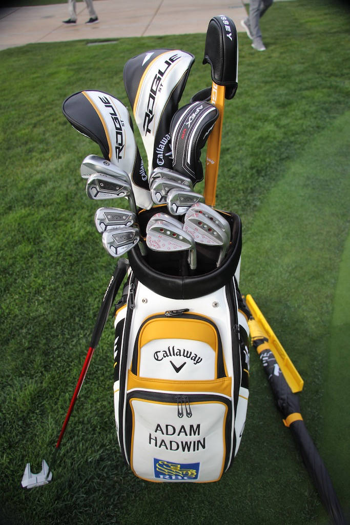 高爾夫 桌布 壁紙 — 一個裝滿球桿的 Callaway 高爾夫球袋放在綠色草地上，附近有一把黃色雨傘。