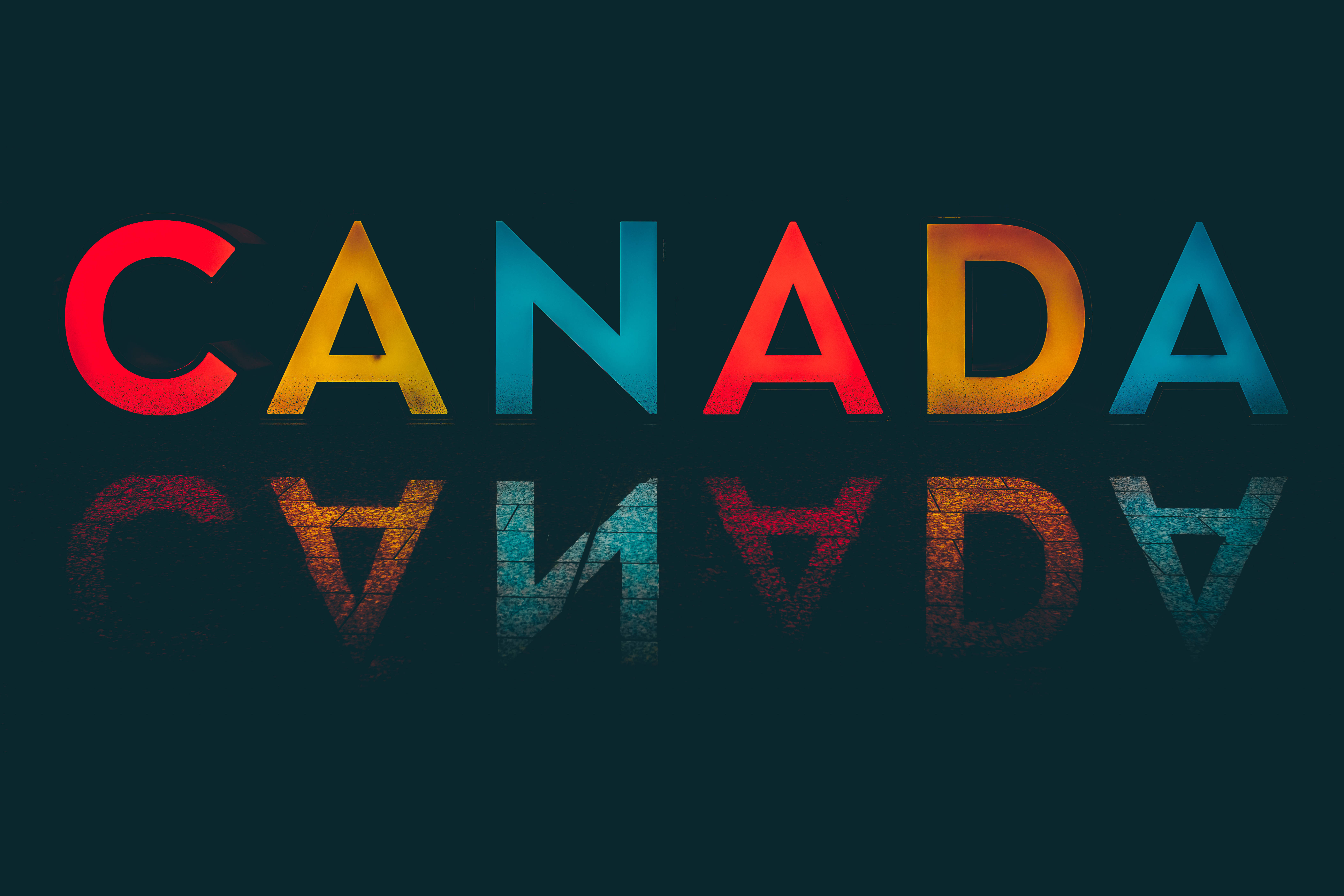 怪奇物語 桌布 壁紙 — 「CANADA」一詞以粗體彩色字母呈現，在深藍綠色背景上帶有紋理反射。