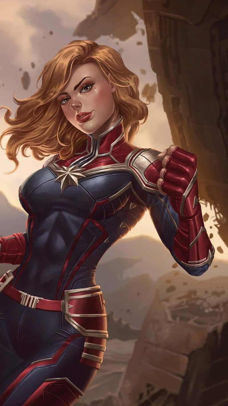 桌布 壁紙 — Captain Marvel 自信地穿著紅藍色制服，胸前有星星標誌，背景是岩石塵土飛揚的戰場。