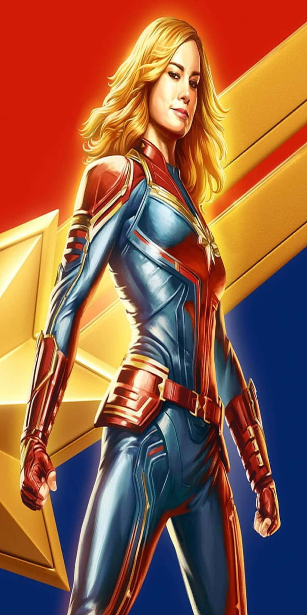 Pixel 3 桌布 壁紙 — Captain Marvel 自信地穿著她的藍色和紅色套裝，站在大膽的紅色和金色星星背景前。