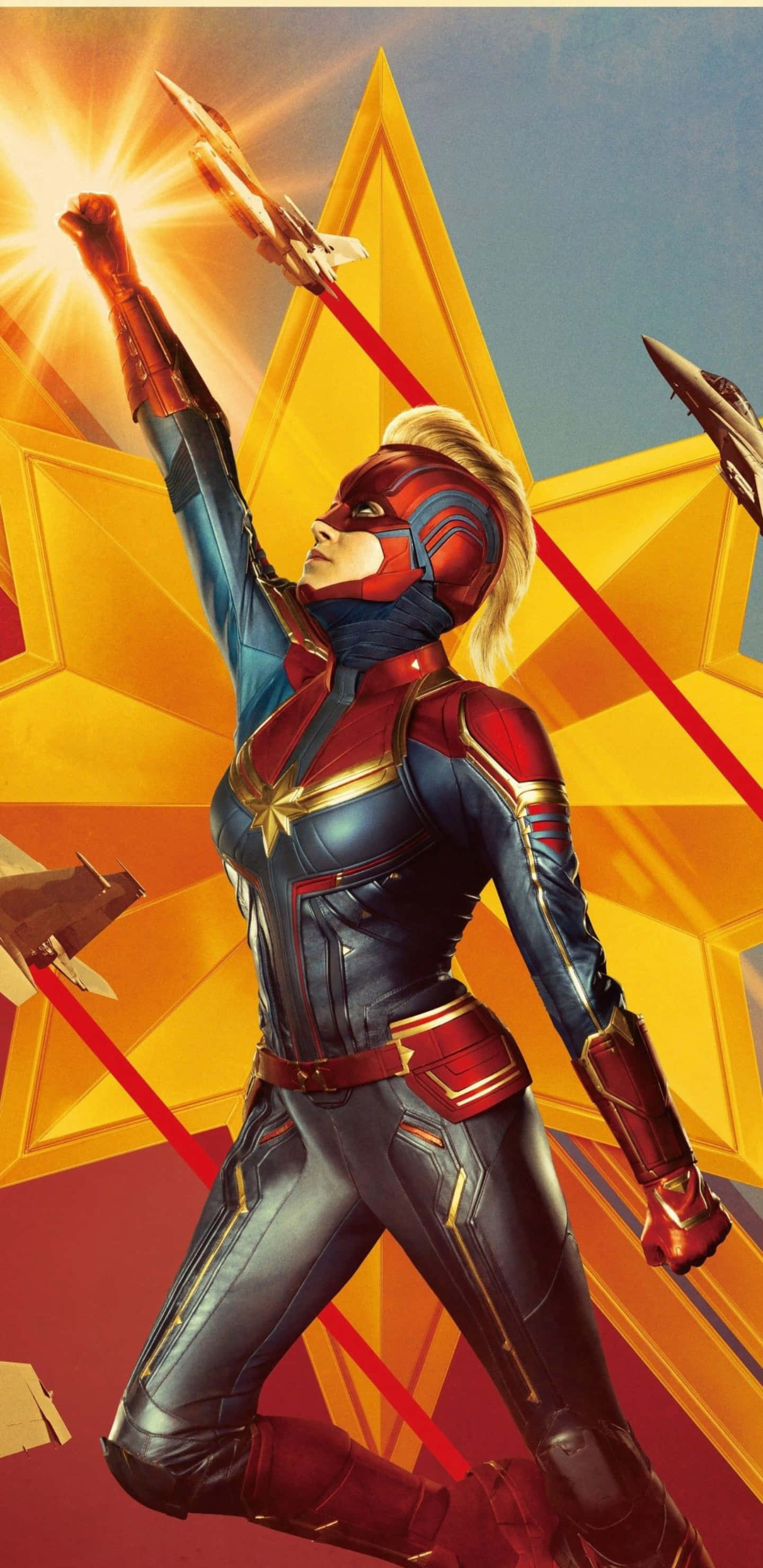Hero 桌布 壁紙 — Captain Marvel 英勇地舉起拳頭，背景是閃耀的金色星星，戰鬥機呼嘯而過。