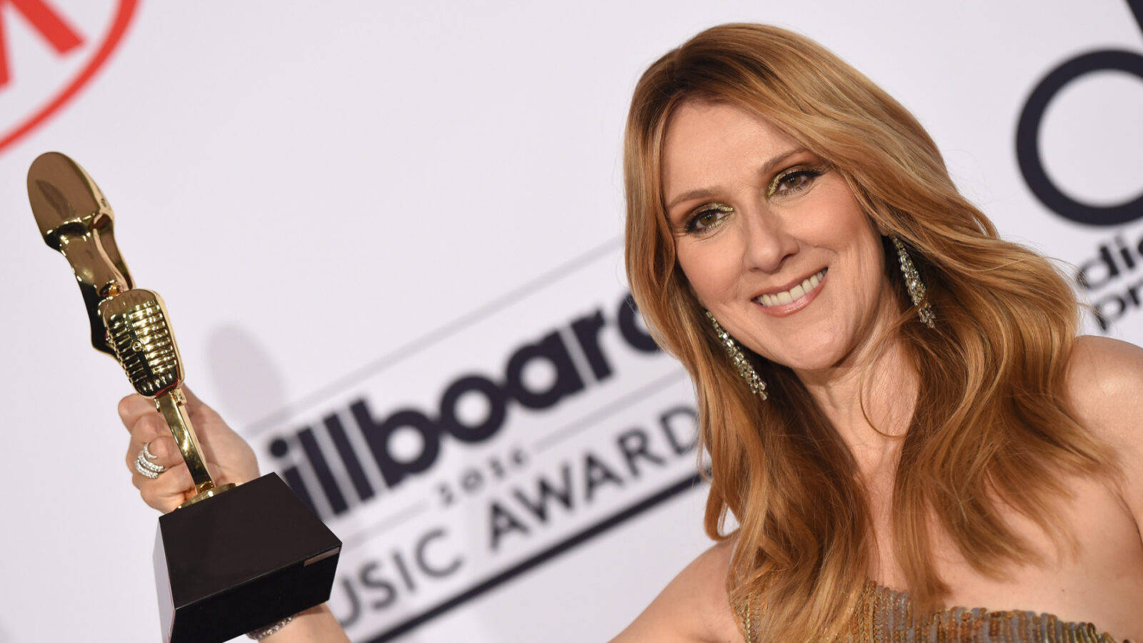 Celine 桌布 壁紙 — Celine Dion 在2016年Billboard音樂獎紅地毯上，手持金色麥克風獎盃，露出燦爛笑容。