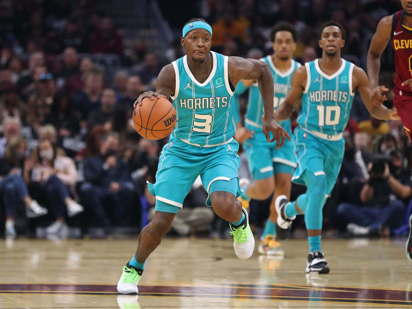 穿著青色黃蜂隊球衣的籃球運動員在比賽中運球。 — NBA 壁紙