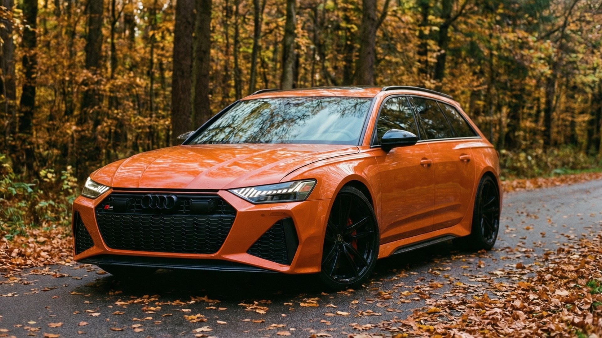 Autumn RS6 壁紙 — 一輛充滿活力的橙色奧迪RS6 Avant旅行車停在落葉滿地的森林道路上，周圍是秋天的樹木。