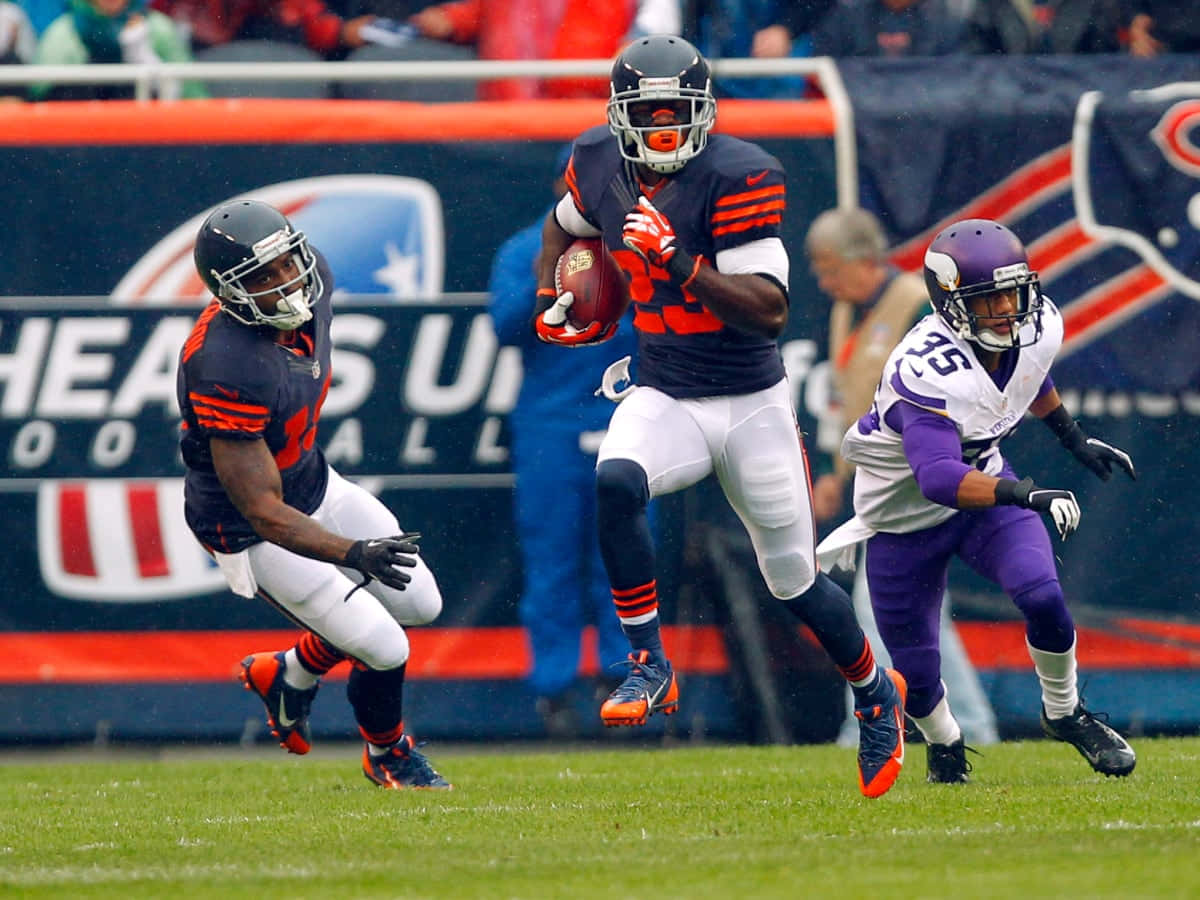  壁紙 — 芝加哥熊隊的跑鋒帶著橄欖球向前躍起，而兩名明尼蘇達維京人隊的防守球員在雨中比賽中逼近。