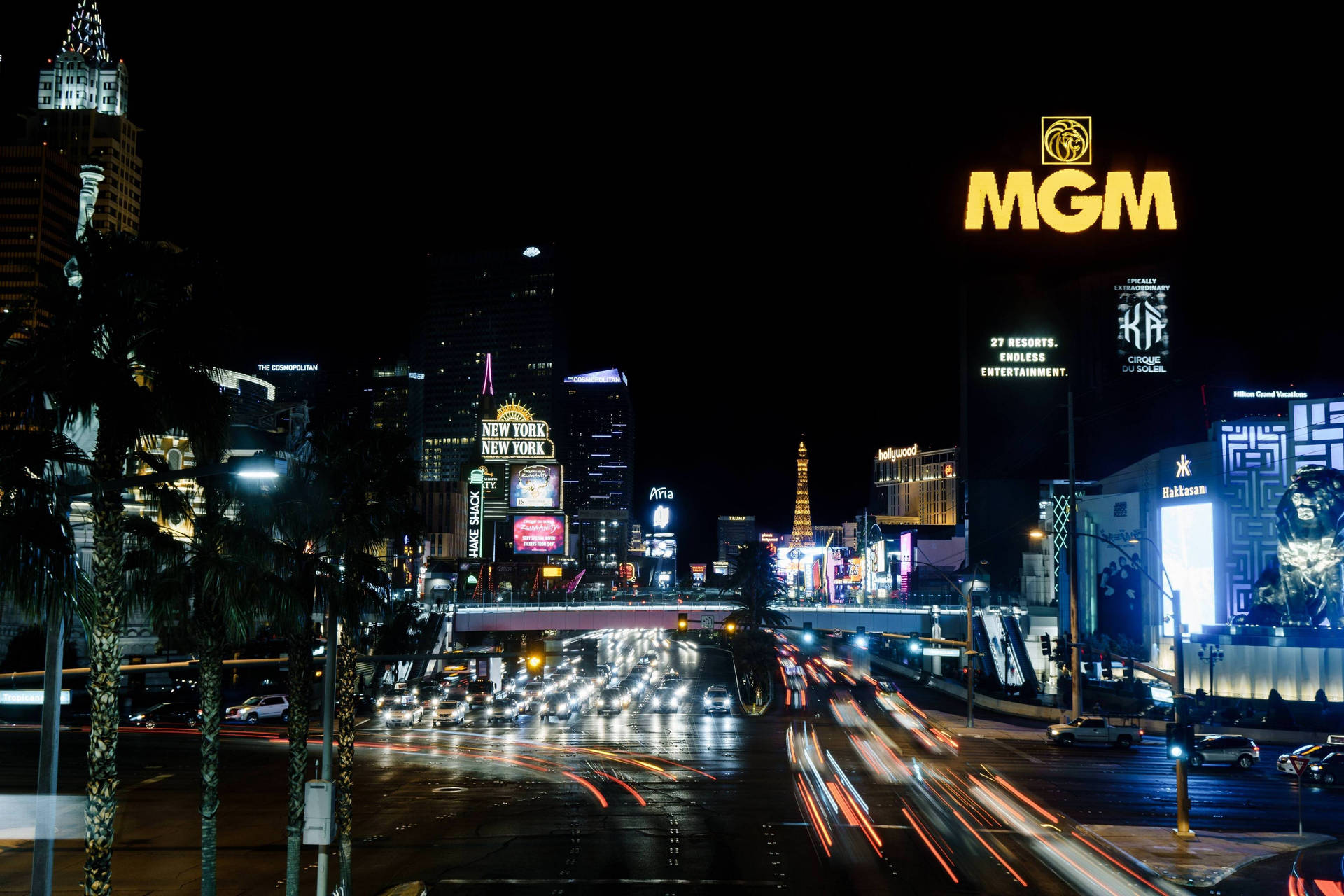 夜晚的拉斯維加斯大道，閃爍的賭場招牌和流動的車燈。 — 4K 壁紙