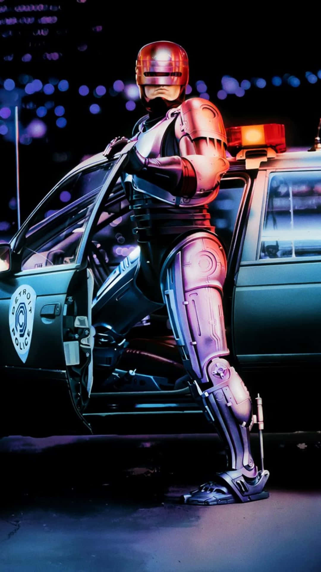  壁紙 — 一名鍍鉻機器人警察在夜晚的霓虹燈光下站在巡邏車旁邊。
