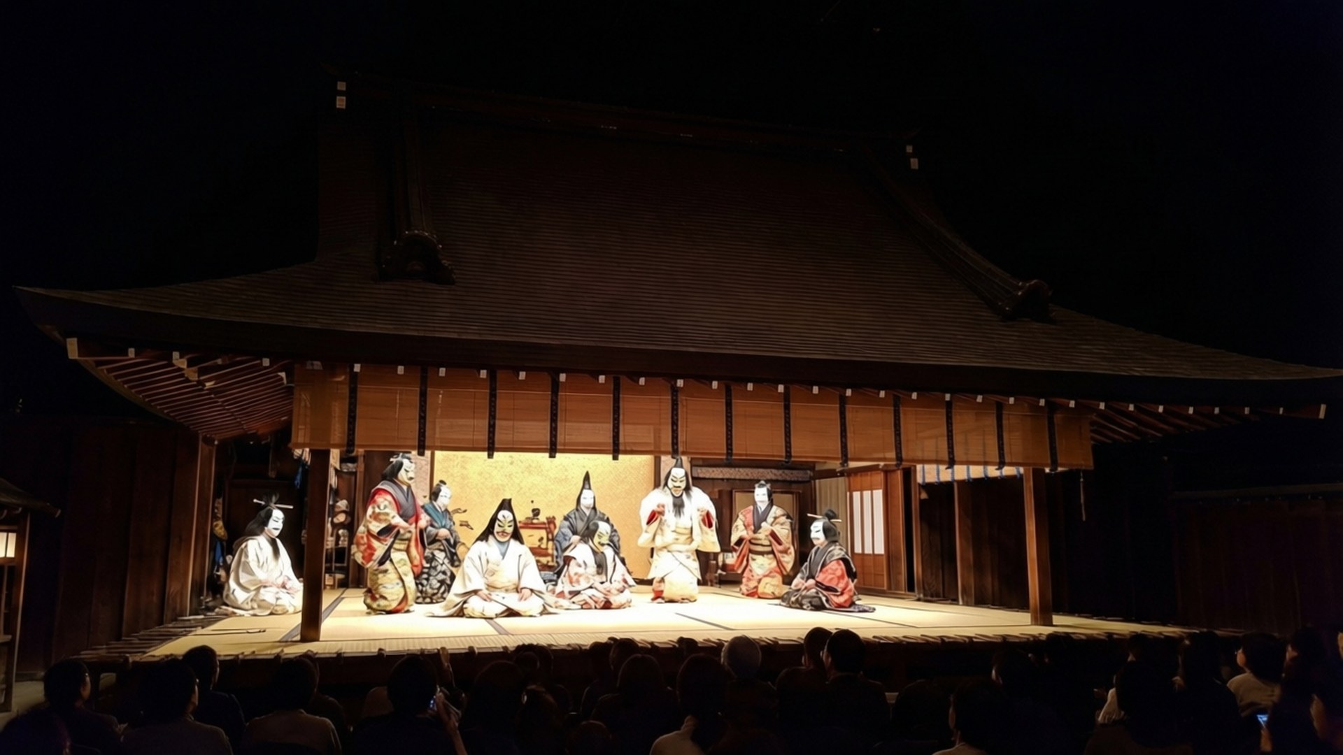 Noh Theater Performance 壁紙 — 傳統能劇演員身穿精緻服飾和面具，在夜間木製舞台上於溫暖聚光燈下端坐。
