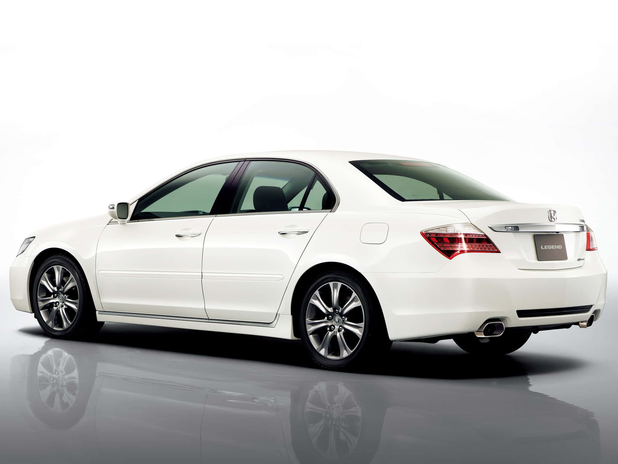 Honda Legend 桌布 壁紙 — 一輛純白色的本田Legend轎車在攝影棚燈光下閃耀，完美倒映在光澤地板上。