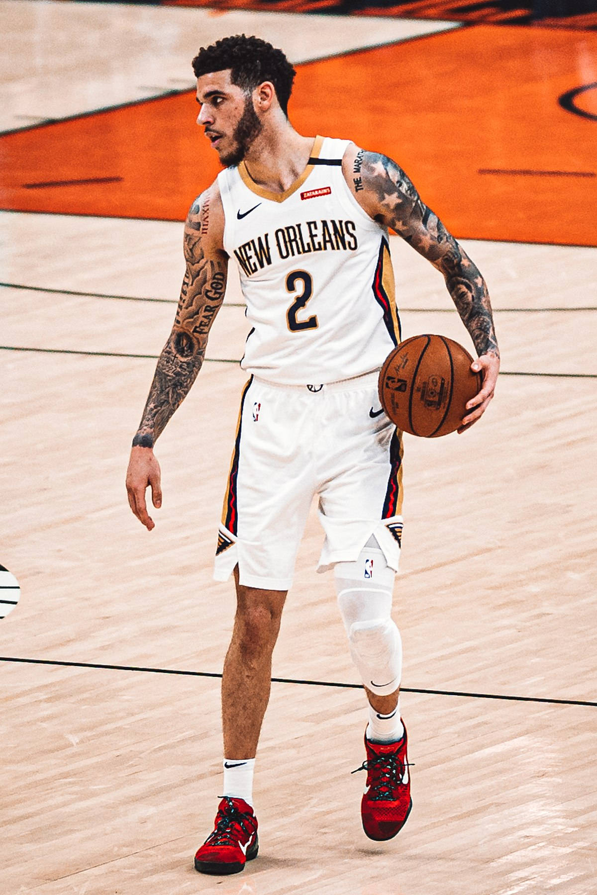 職業籃球運動員穿著紐奧良球衣在比賽中運球。 — NBA 壁紙