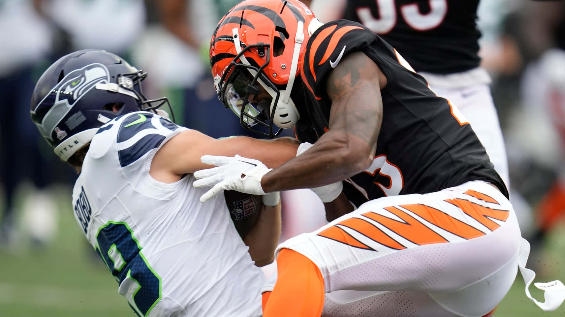 壁紙 — 辛辛那提猛虎隊的線衛在激烈的NFL美式足球比賽中擒抱西雅圖海鷹隊的跑衛。