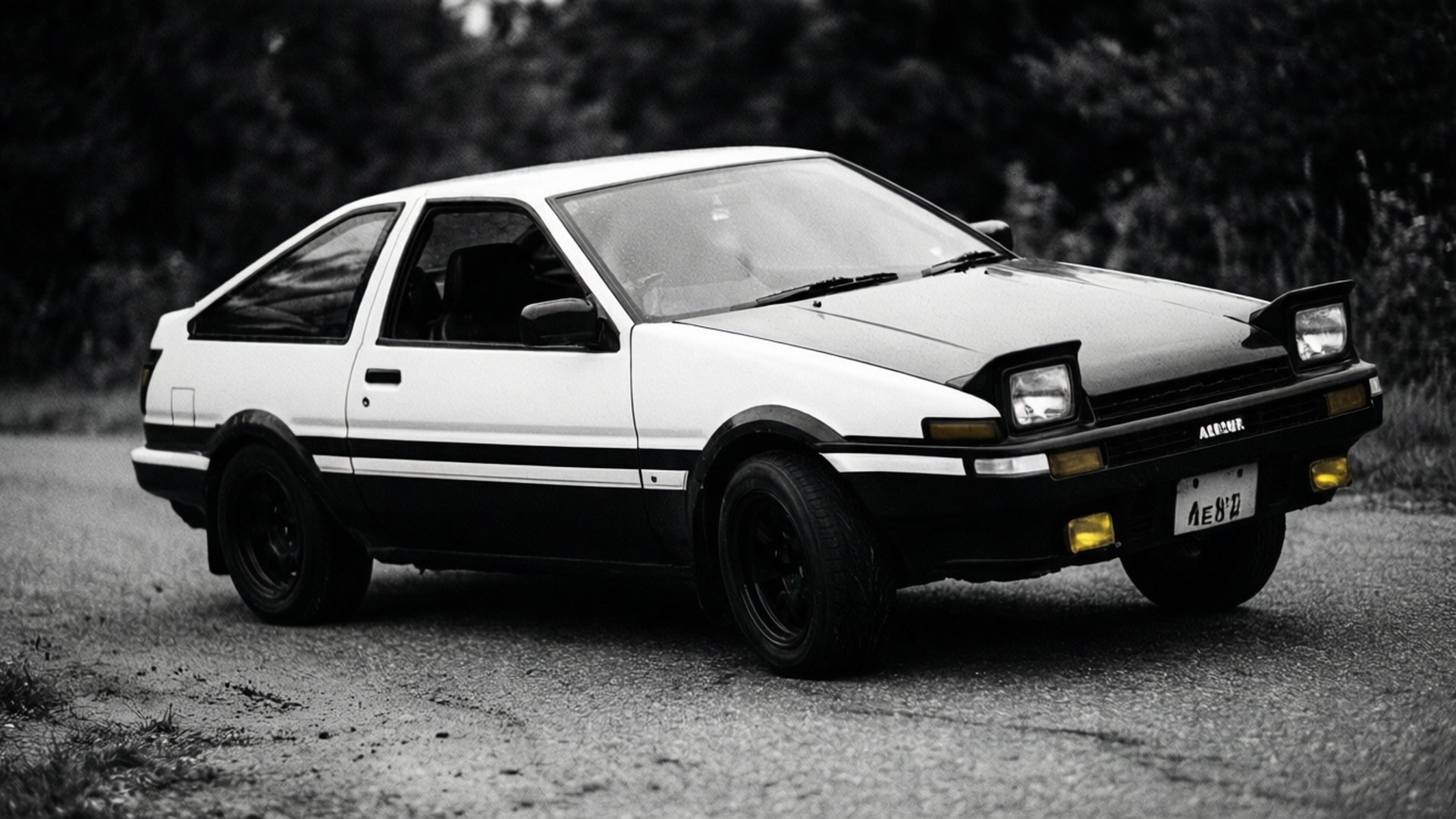 Monochrome Drift 壁紙 — 經典黑白AE86豐田Corolla Levin停泊在碎石路上，背景有樹木。