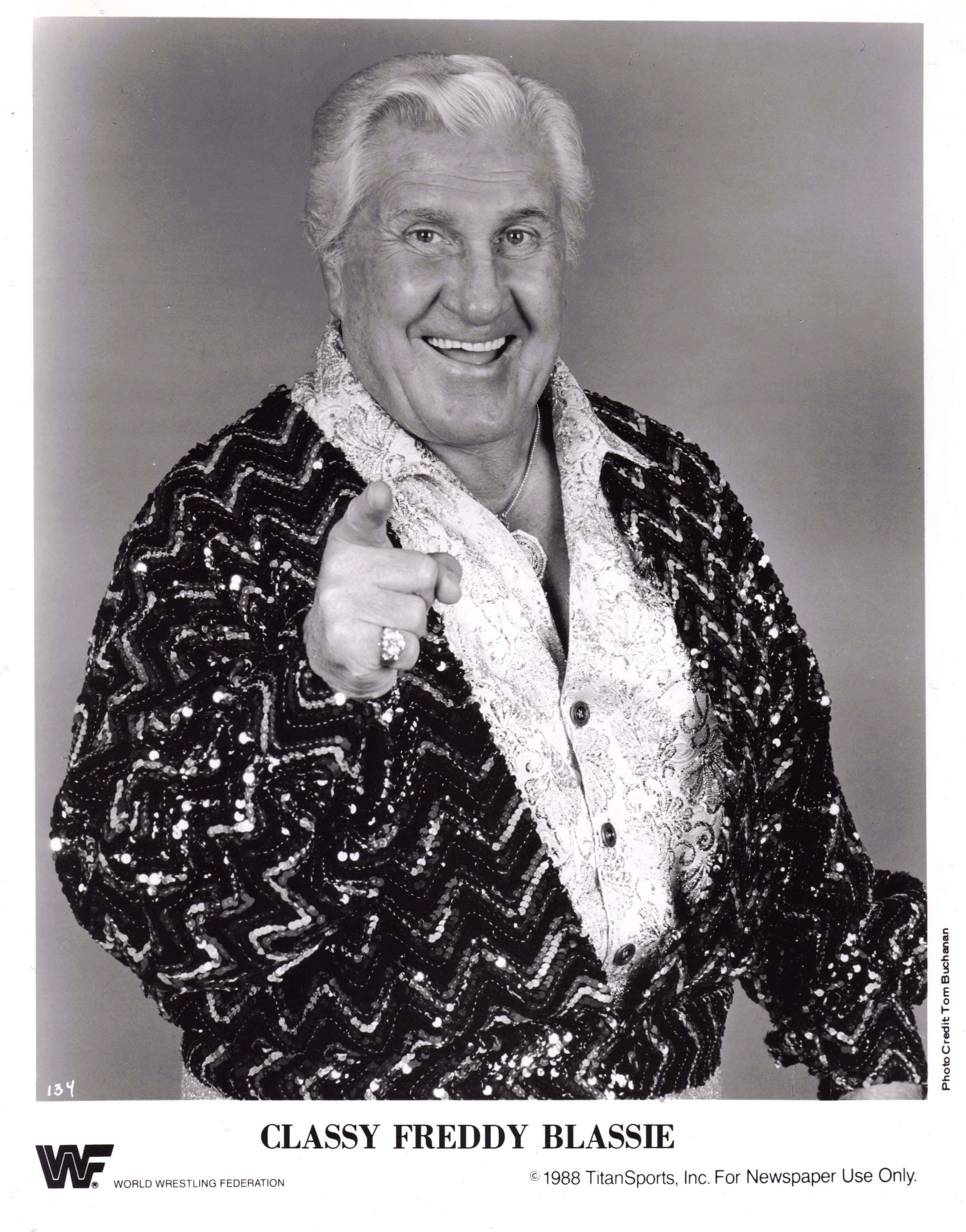 黑白 桌布 壁紙 — Classy Freddy Blassie 燦爛地微笑，並穿著閃亮亮片外套直接指向觀眾。