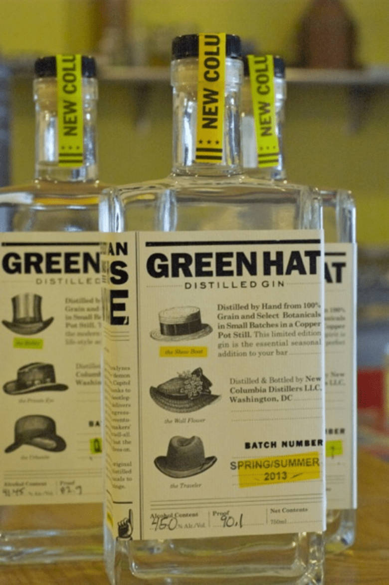 alcohol 桌布 壁紙 — Green Hat Distilled Gin 的透明玻璃瓶，帶有復古帽子插圖和頸部黃色「NEW COL」膠帶。