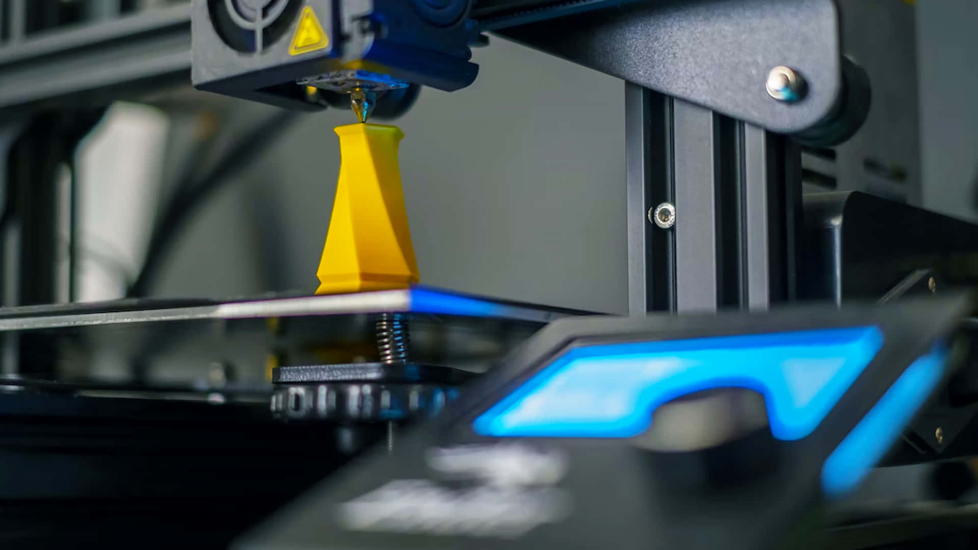 3D列印機擠出黃色塑料以創建幾何形狀。 — 3D 壁紙