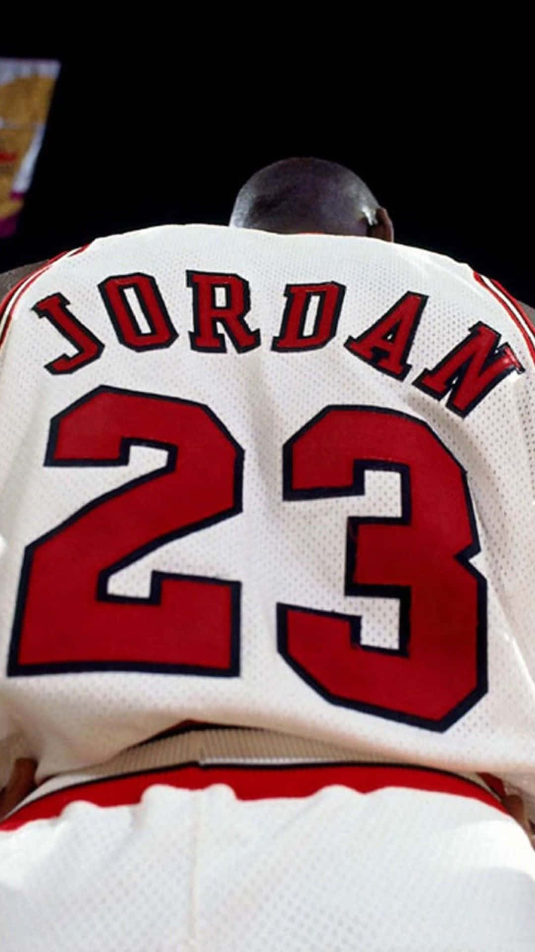 身穿白色 Jordan 23 球衣的籃球運動員背面視圖。 — 邁克爾·喬丹 4K 壁紙