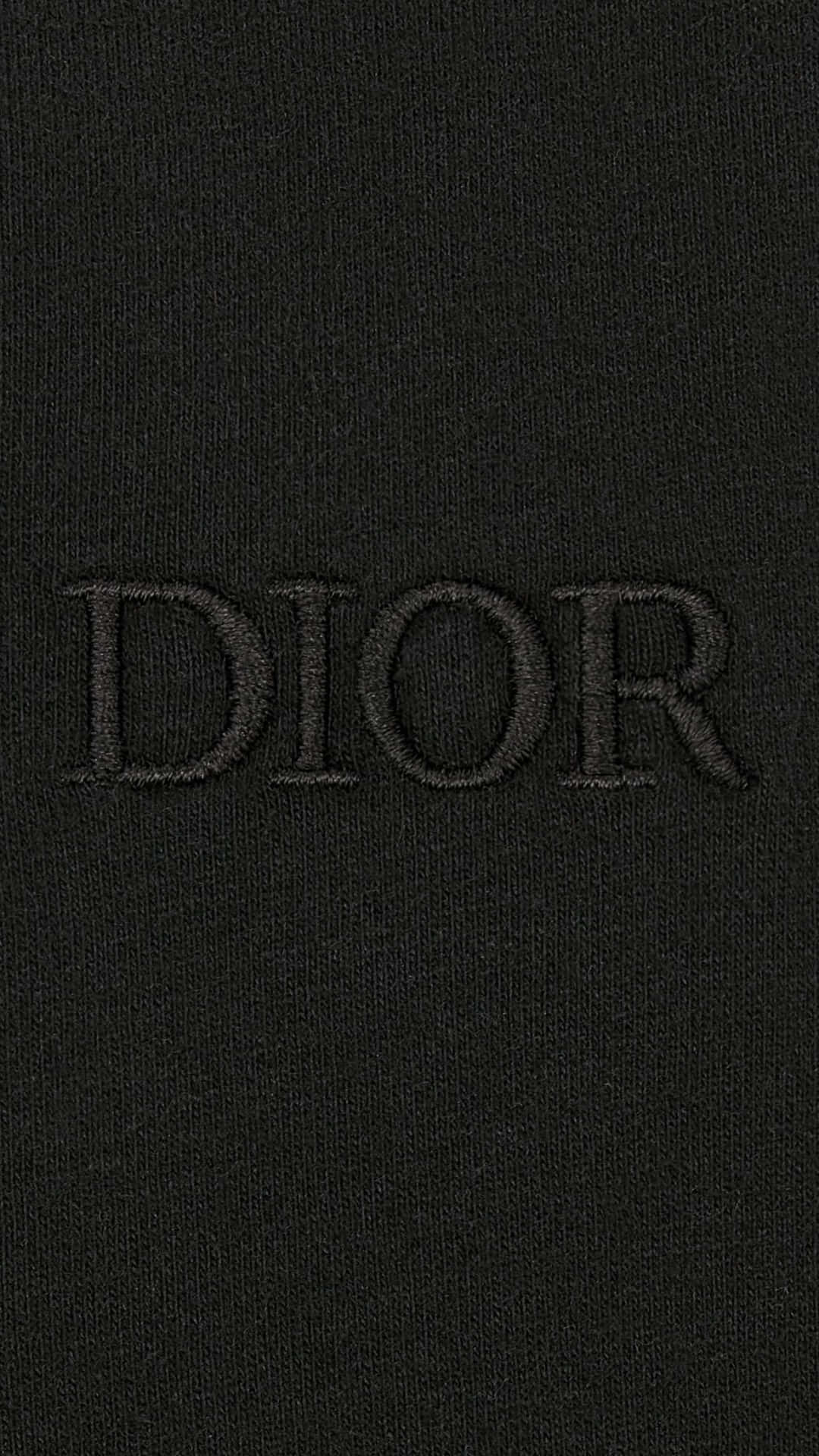  壁紙 — 黑色針織布料的特寫，DIOR 字樣以相配的深色線低調刺繡。
