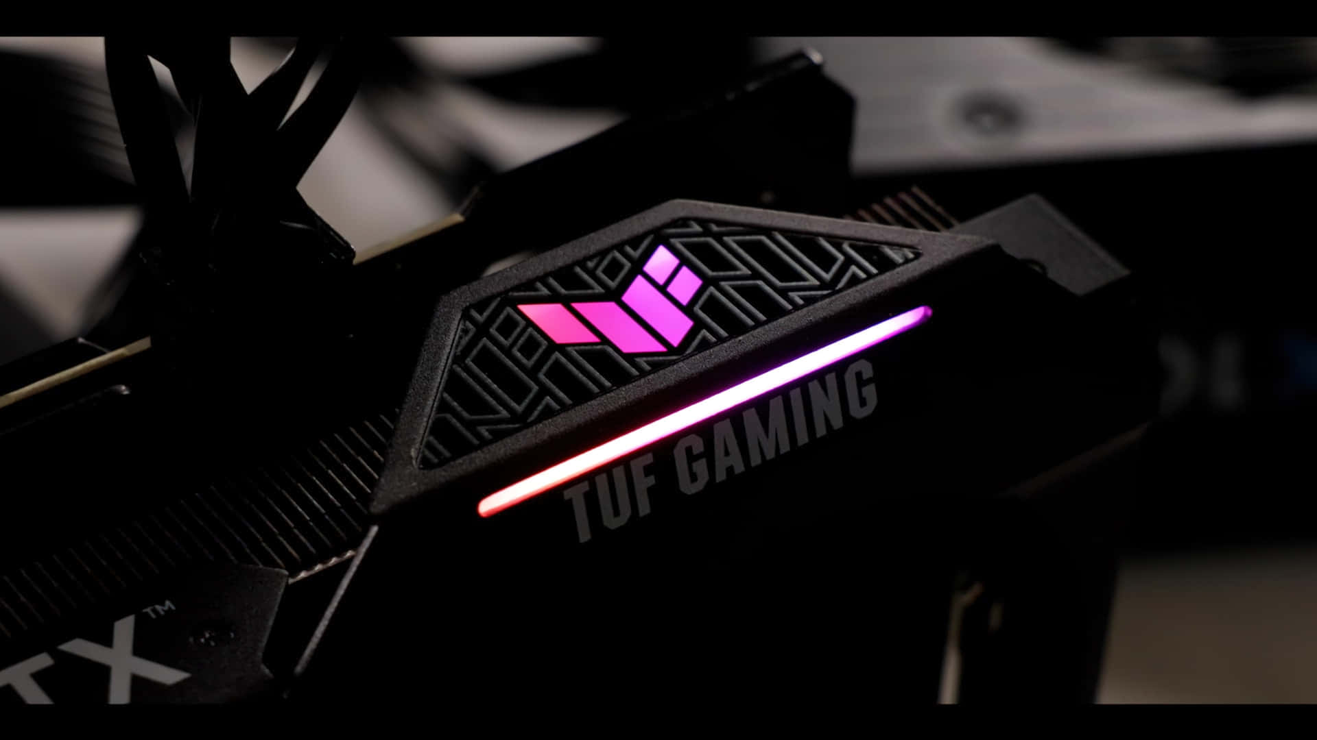  壁紙 — 黑色TUF Gaming顯示卡特寫，在黑暗環境中帶有發光的粉紅色和白色LED裝飾。