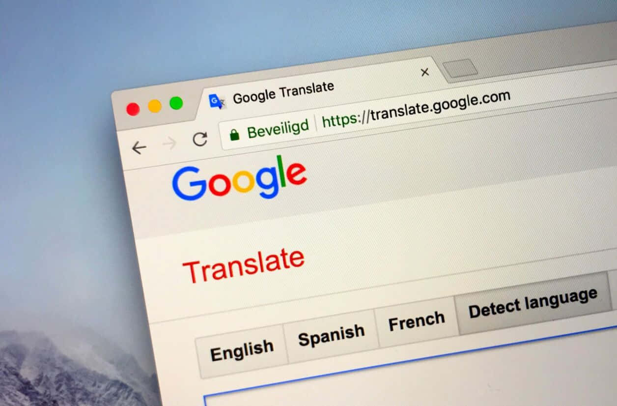 Google翻譯網頁在電腦螢幕上開啟，帶有山脈桌布。 — Google 壁紙