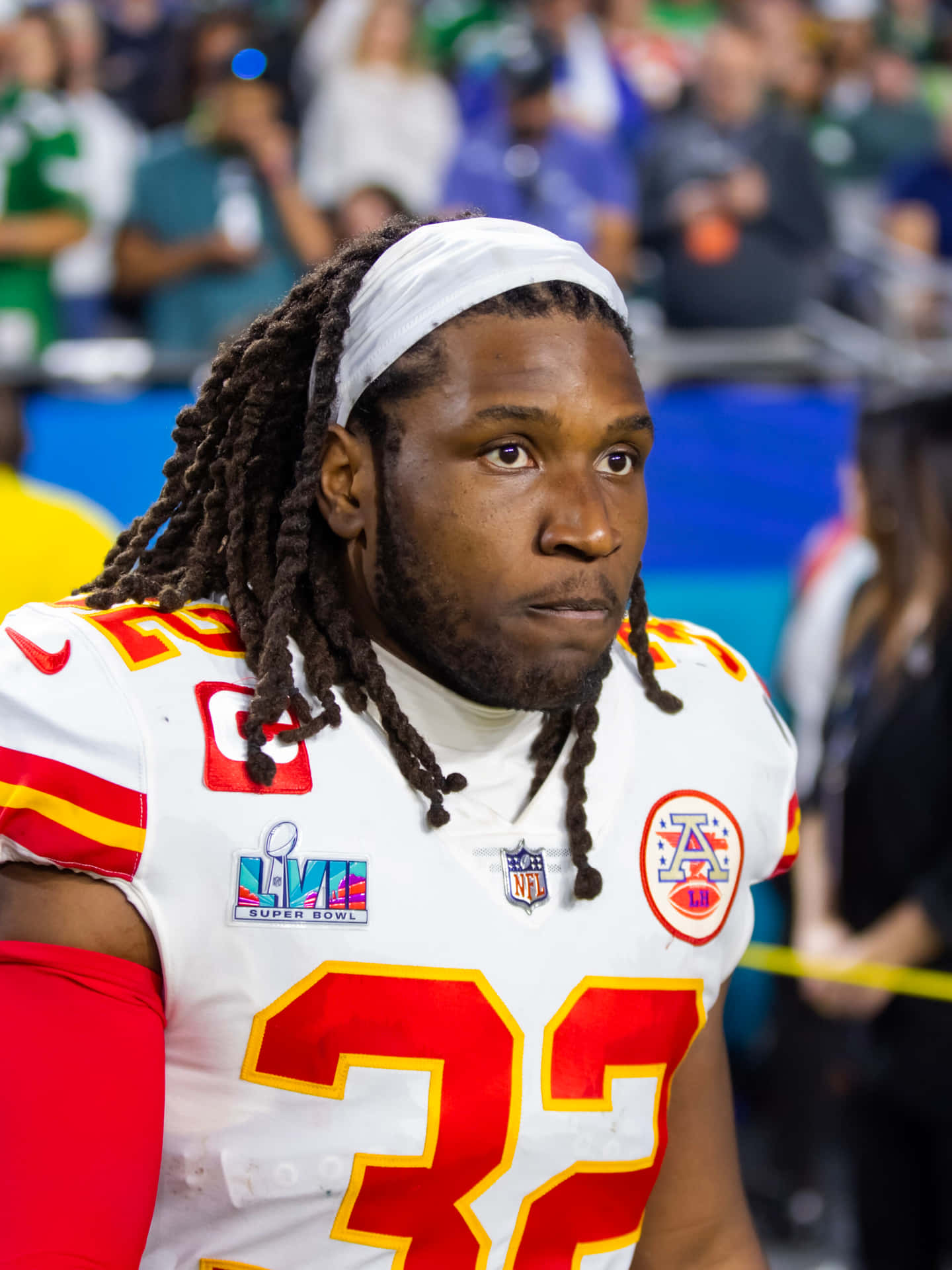  壁紙 — 專注的NFL美式足球員近距離特寫，身穿白色、紅色和黃色球衣，號碼32，比賽中。