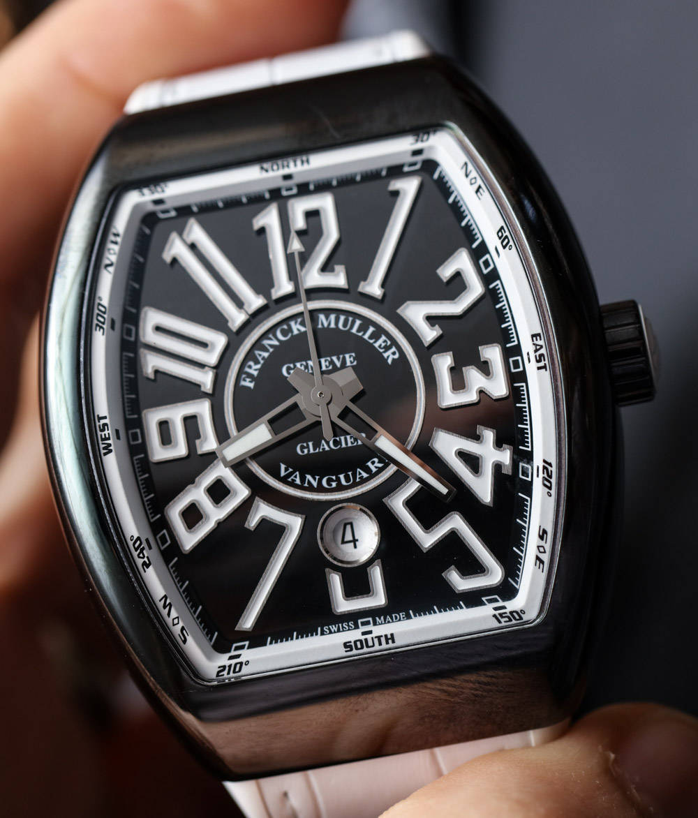 Luxury 桌布 壁紙 — Franck Muller Glacier Vanguard 手錶的特寫，黑色錶盤上有粗體白色數字，握在手中。