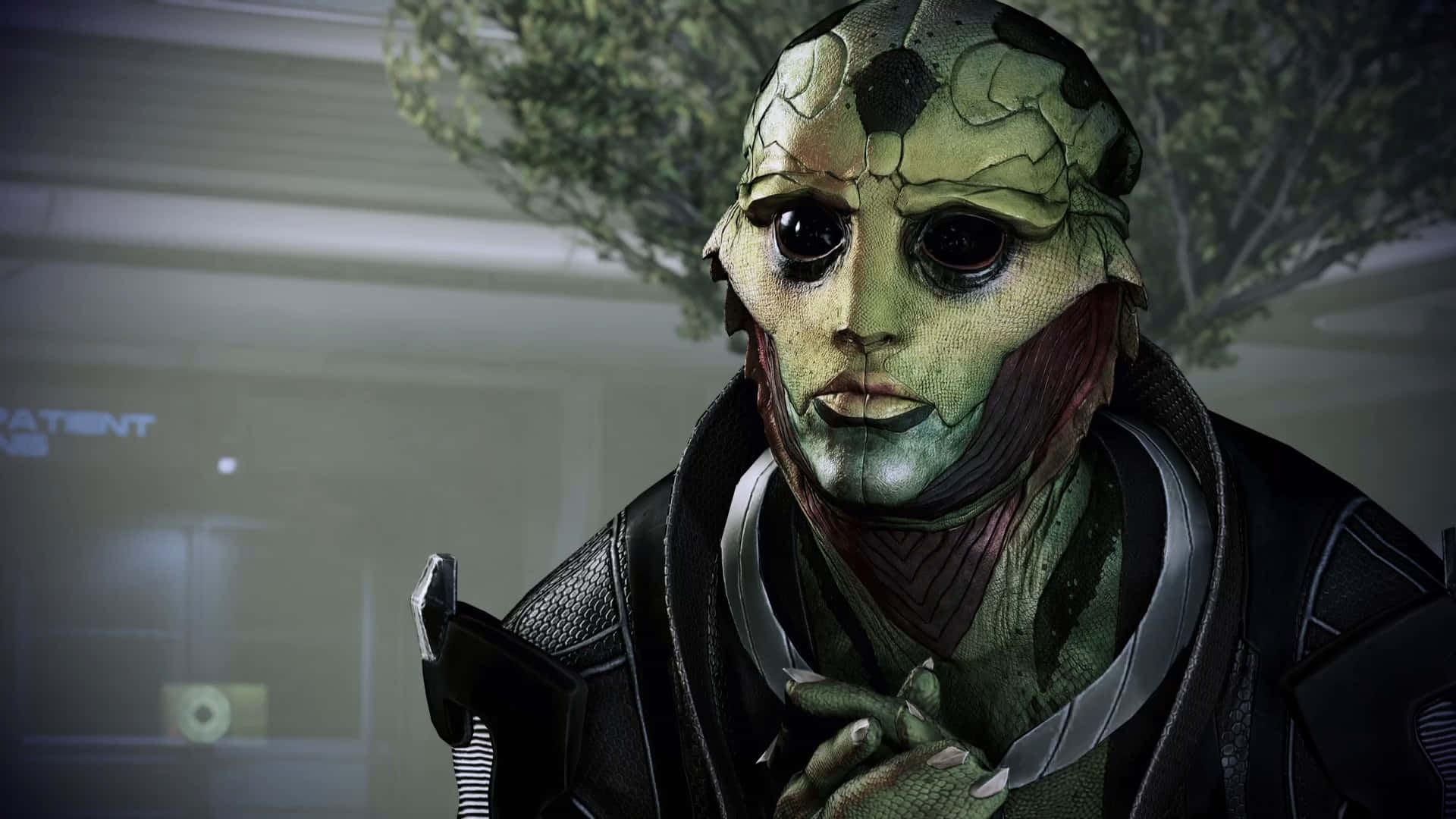 Thane Krios 桌布 壁紙 — 一個綠色皮膚、皮膚龜裂、眼睛又大又黑的外星人特寫，穿著黑色外套，身處燈光昏暗的未來感房間。