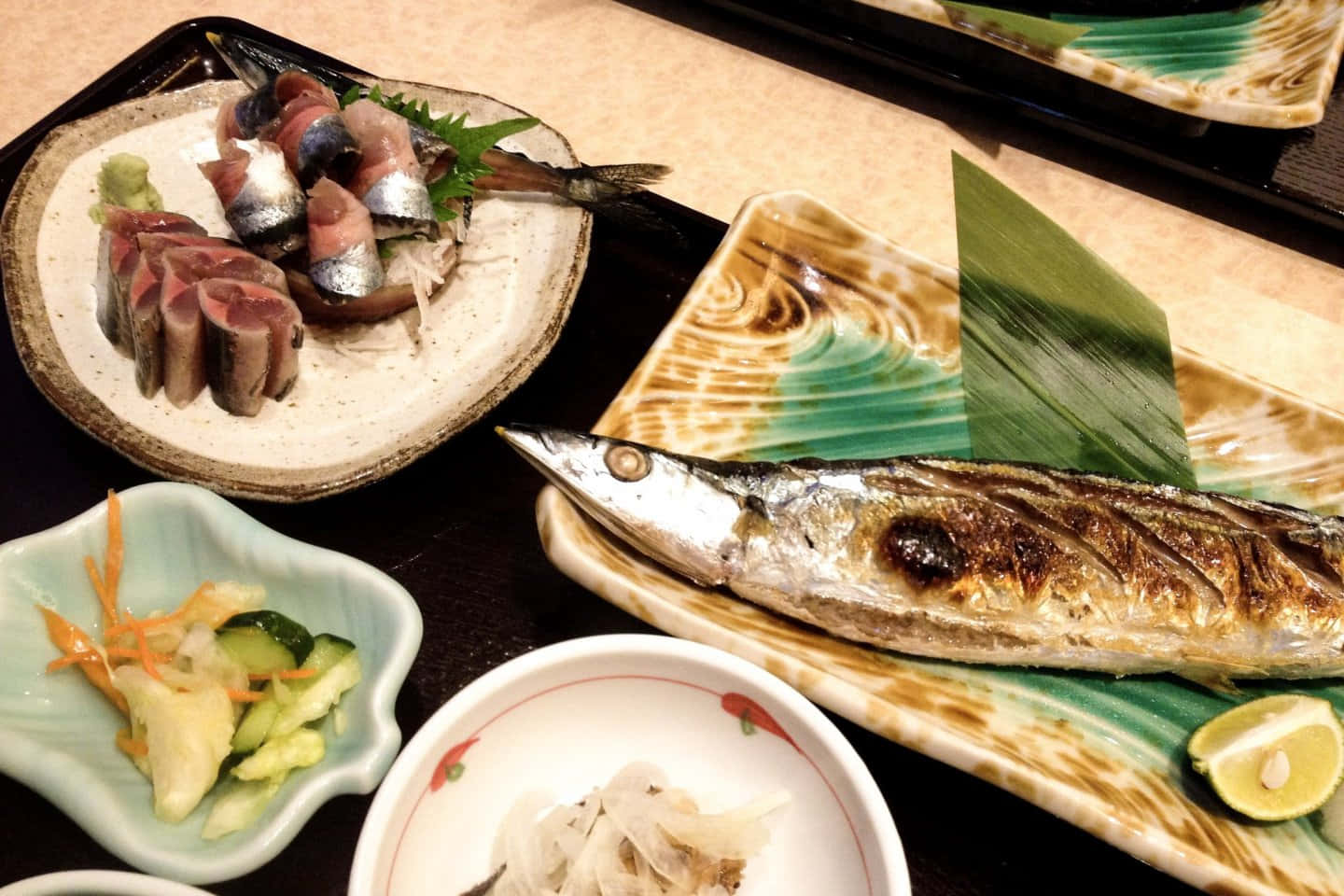 壁紙 — 日本海鮮拼盤的特寫，包括烤鯖魚刺身和醃菜，盛在陶瓷盤上。