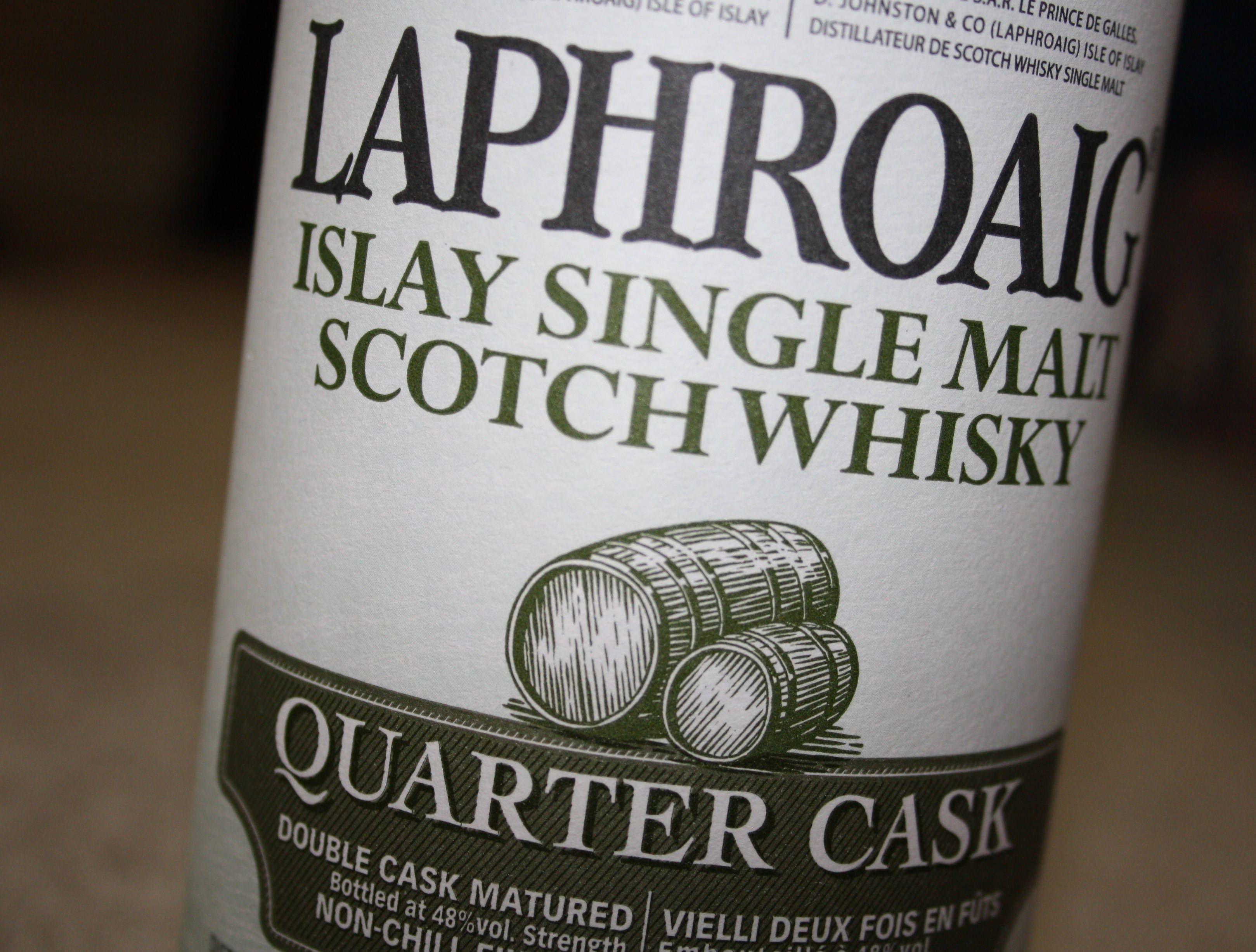 安卓 桌布 壁紙 — Laphroaig Islay Single Malt Scotch Whisky 酒瓶標籤的特寫，顯示 quarter cask 細節和木桶插圖。