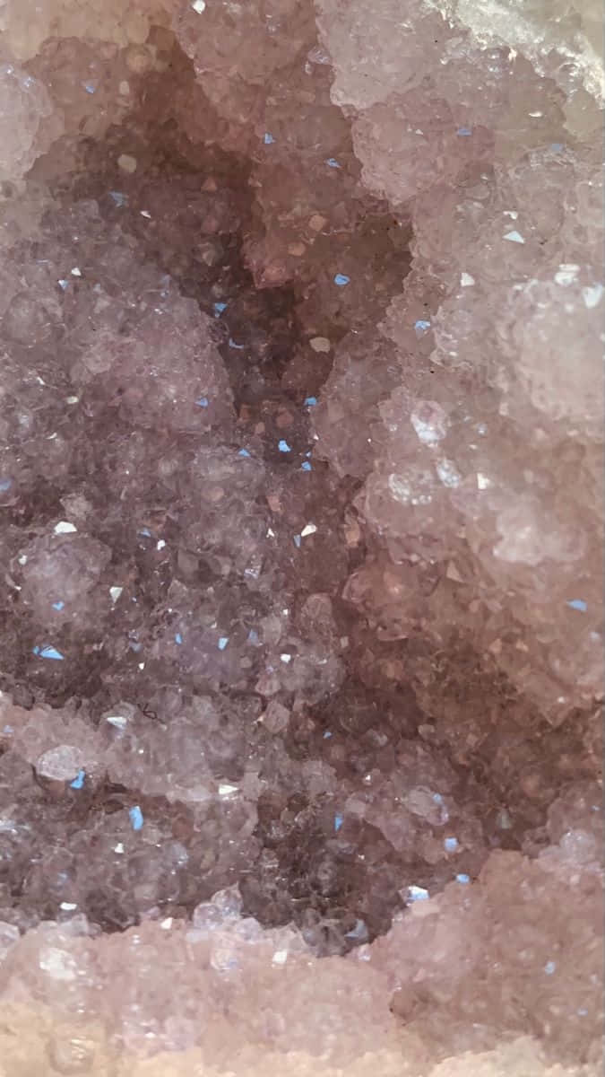 壁紙 — 粉紅紫水晶晶洞的特寫，展現出閃閃發光的晶體結構，內嵌藍色斑點。
