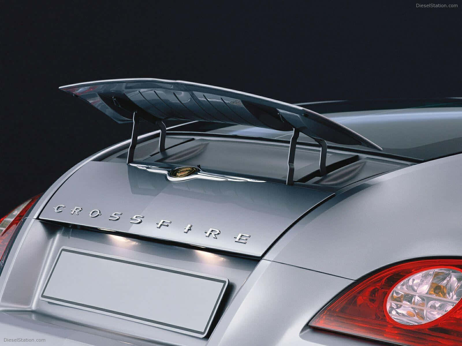 Chrysler Crossfire 桌布 壁紙 — 銀色保時捷 Crossfire 車尾特寫，帶有突出的尾翼和發光的紅色尾燈，背景為深色。