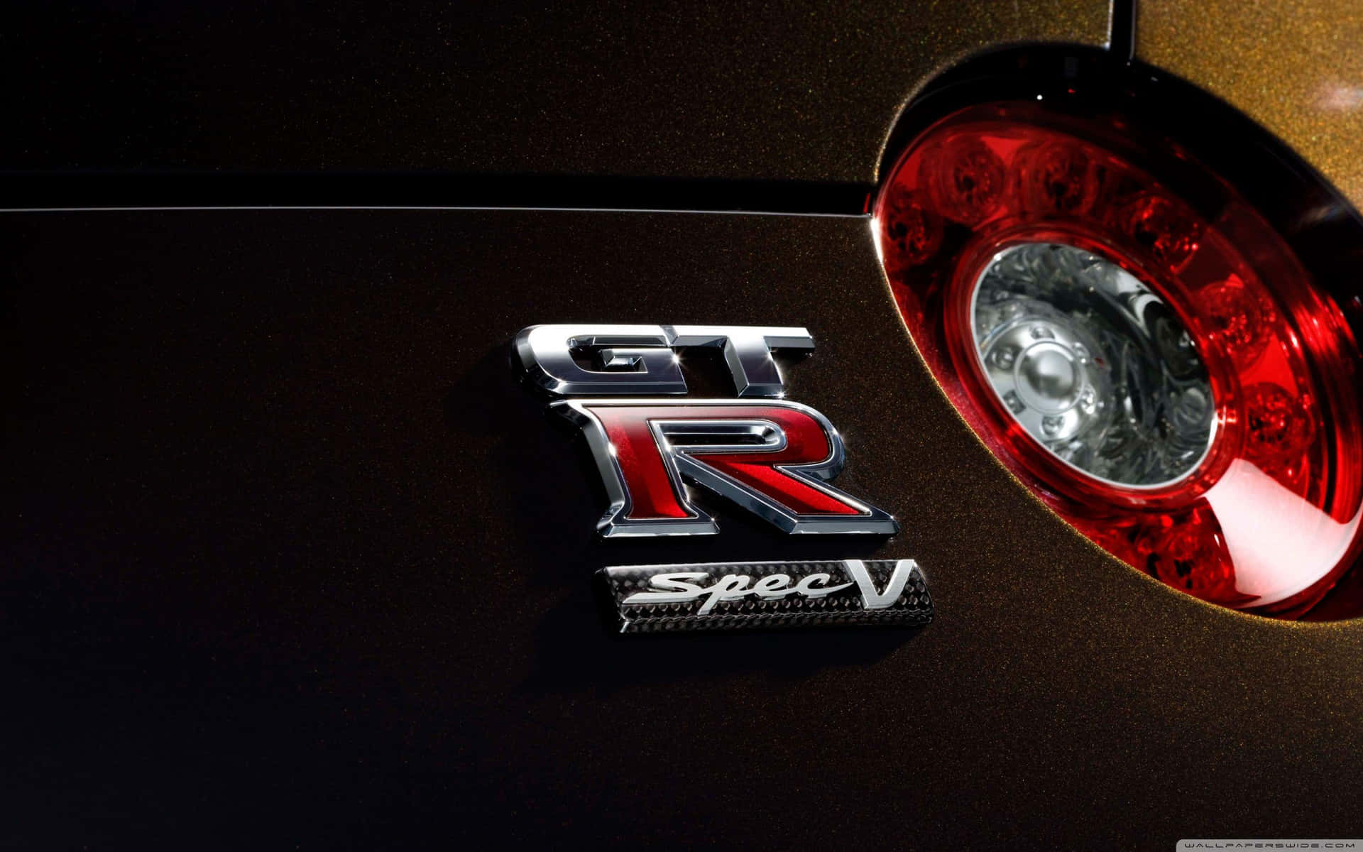 GT-R Spec V 汽車徽章和紅色尾燈特寫。 — 日產GTR 壁紙